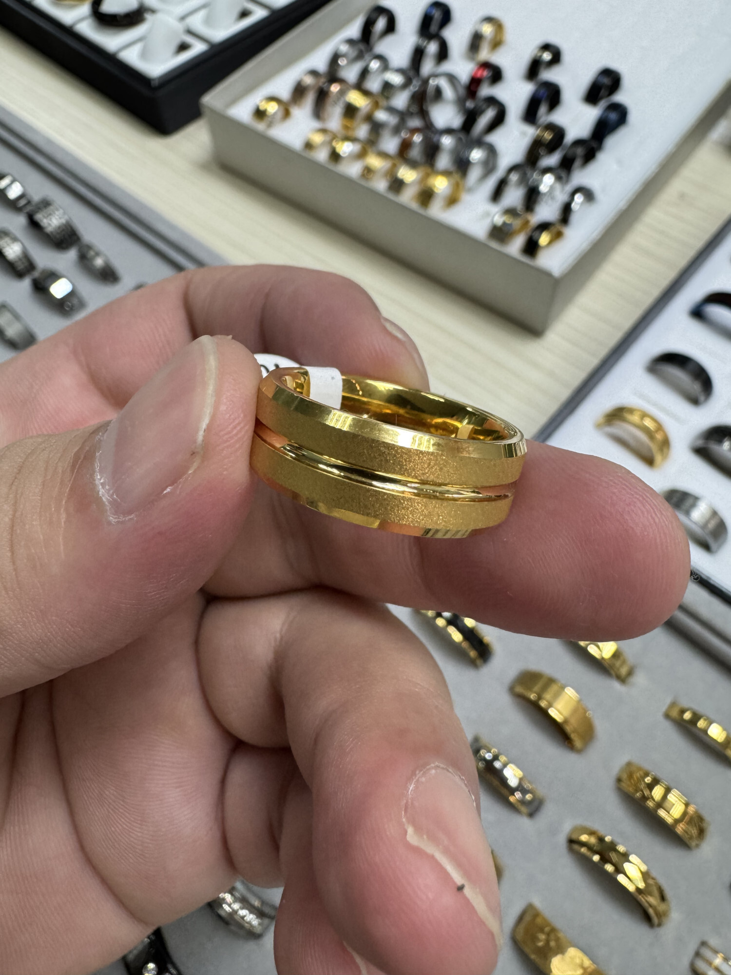Muestra de anillo dorado en mano; soporte para personalización y producción al por mayor