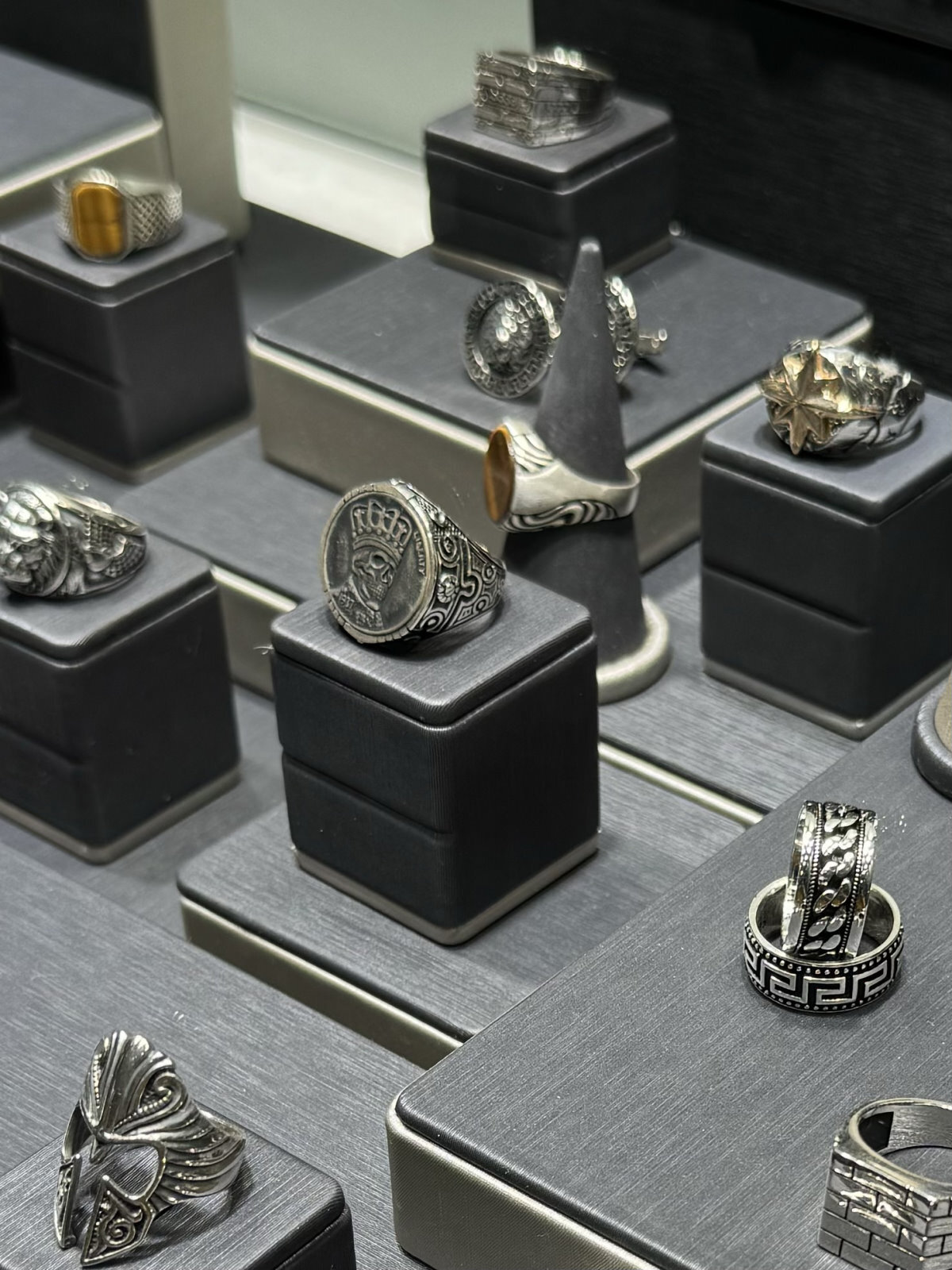 Anillos de plata de estilo vintage con grabados y diseños únicos, expuestos en vitrina