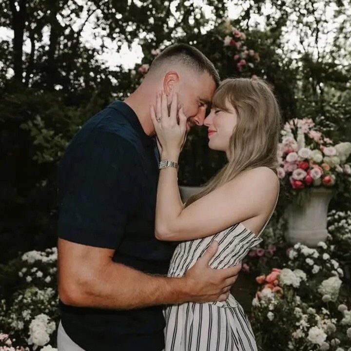 Taylor Swift and Travis Kelce embracing outdoors in a garden with flowers. They are getting married.