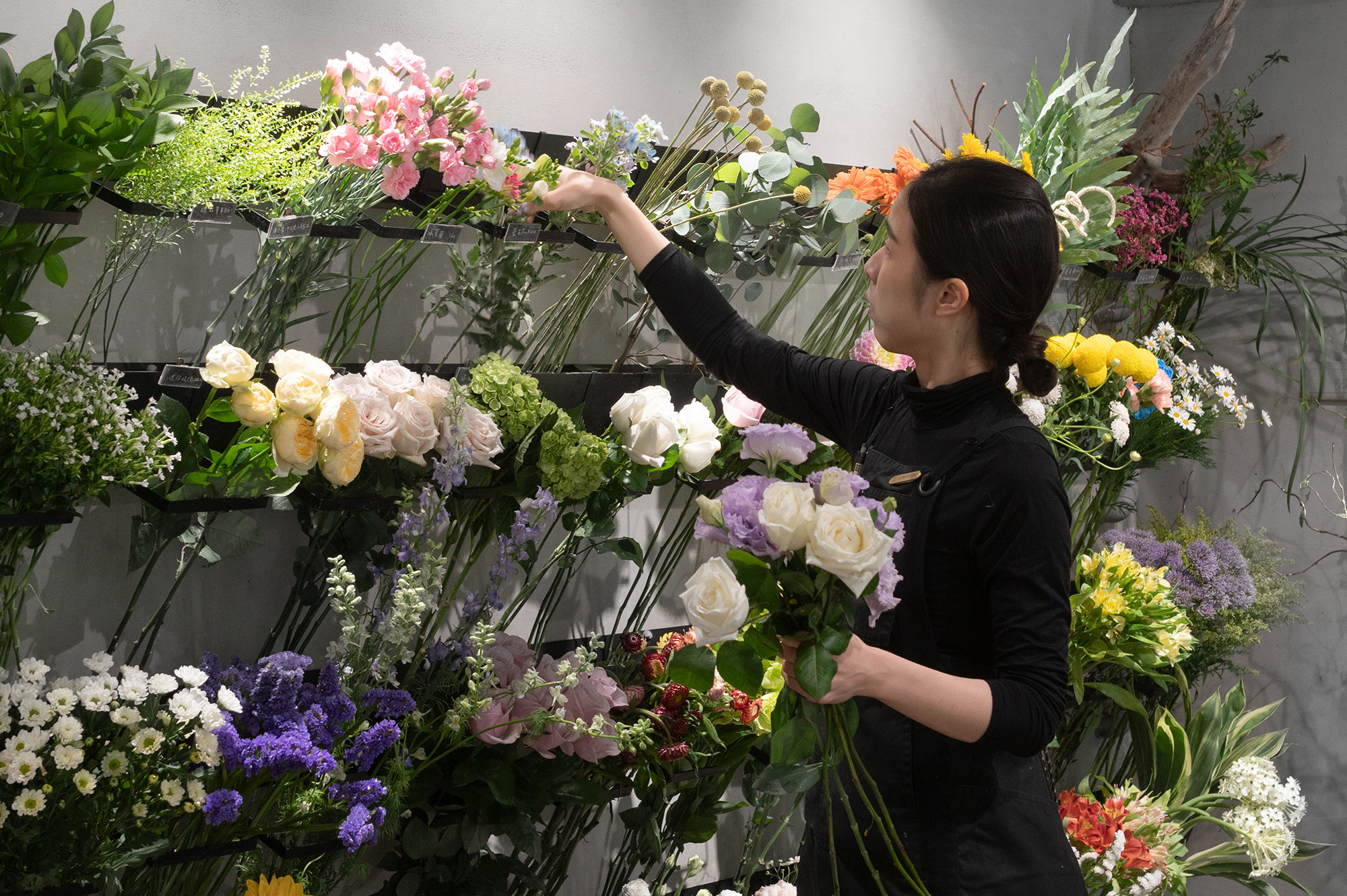 花藝師在花店選花綁花