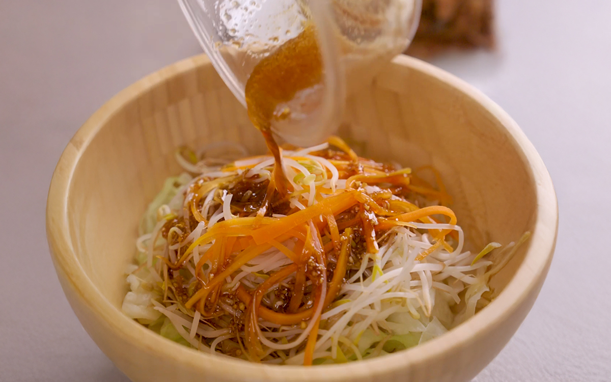 把醬汁淋在蔬菜上後舖上燒肉片