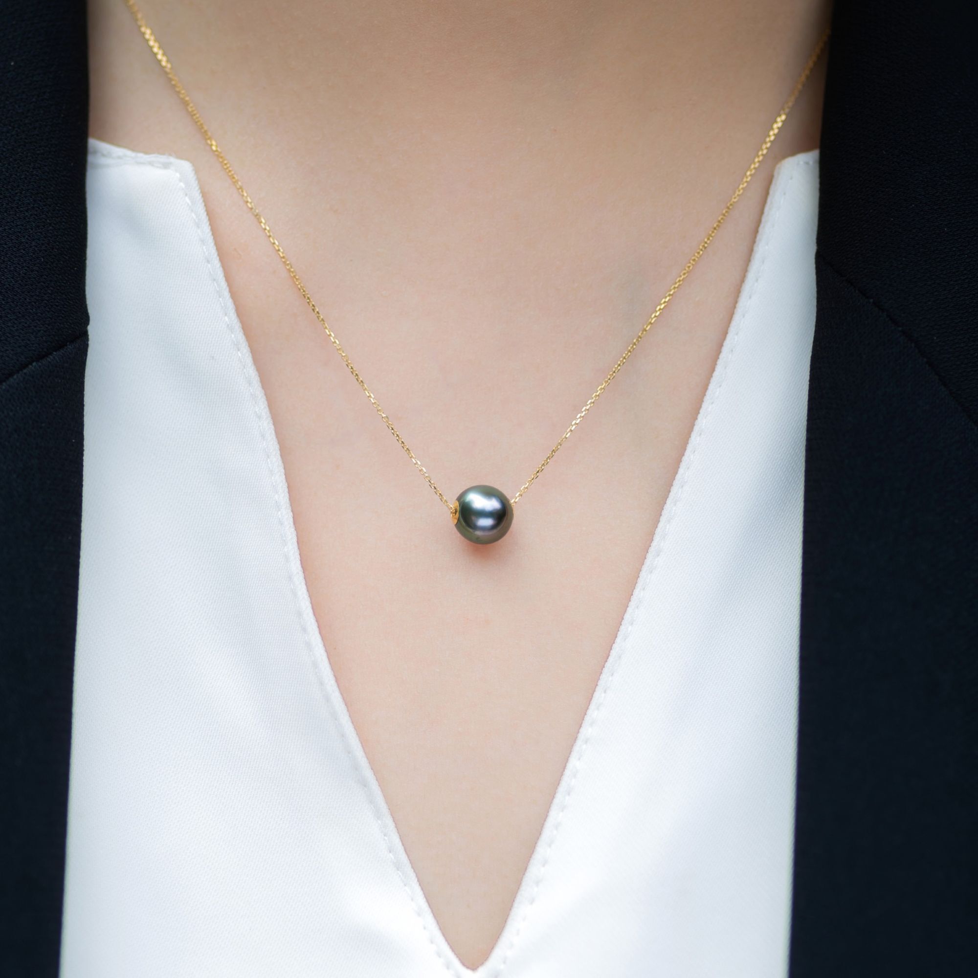 A black tahitian pearl 18K necklace with green overtone.