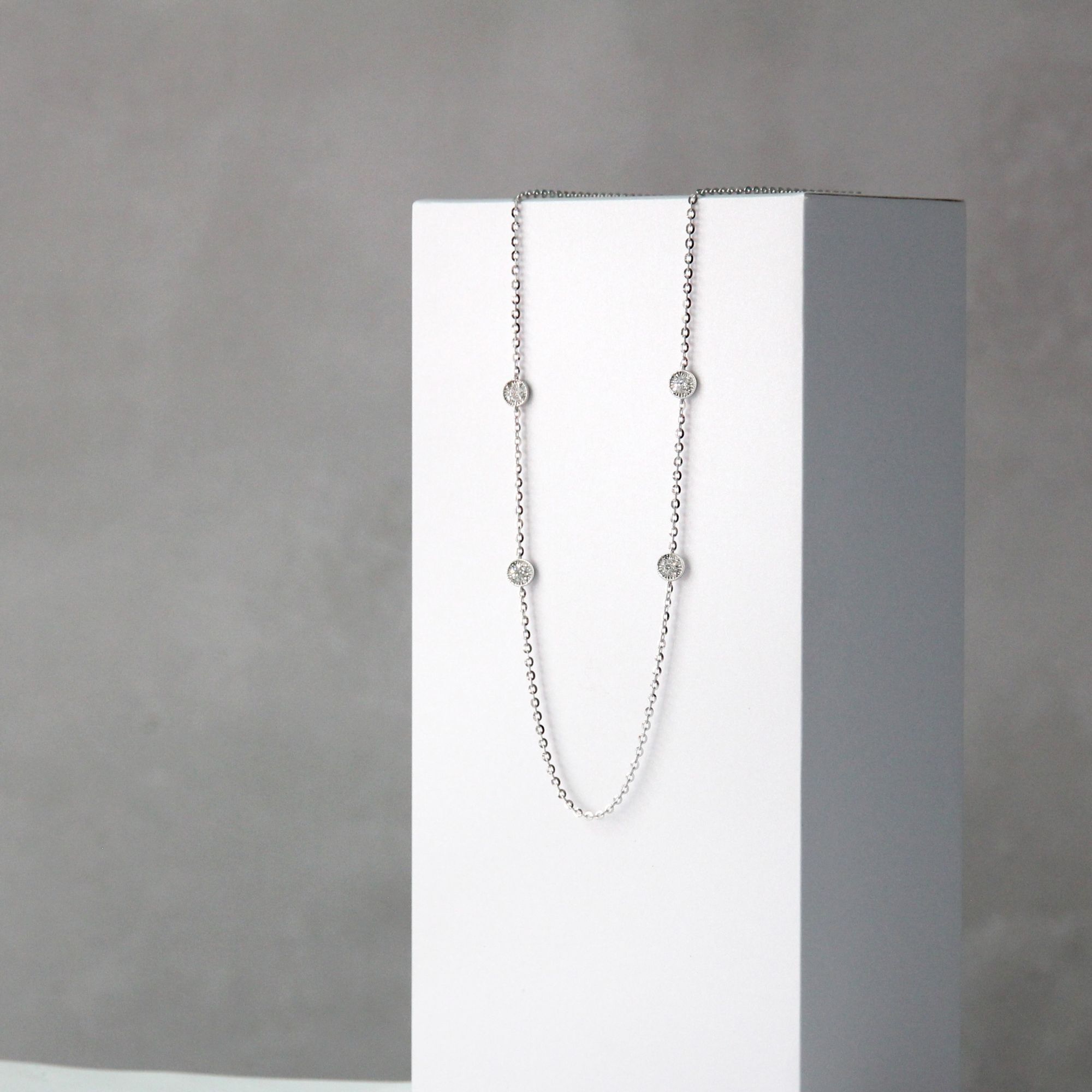 A Martinee necklace with 4 diamonds.