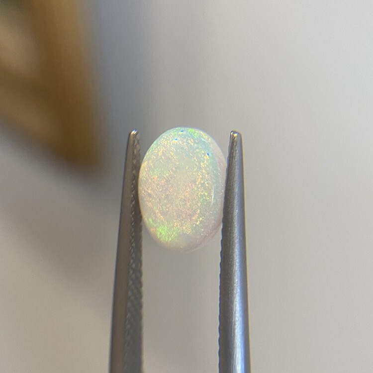 A 1.55-carat white opal displaying soft pastel play-of-color.