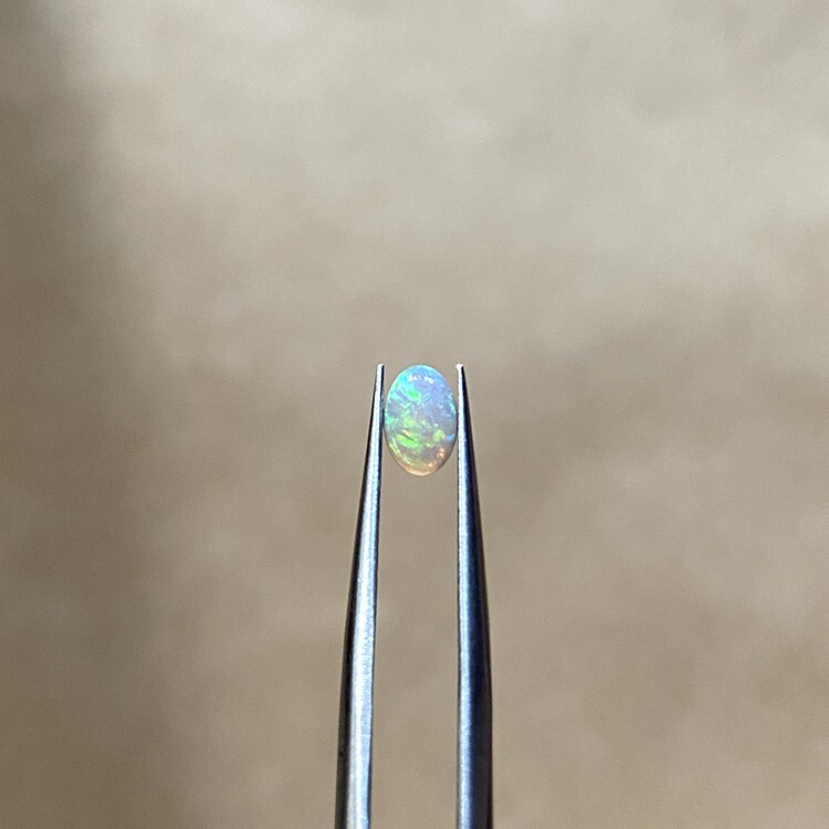 A 0.26-carat crystal opal showing vivid blue, orange, and green play-of-color.
