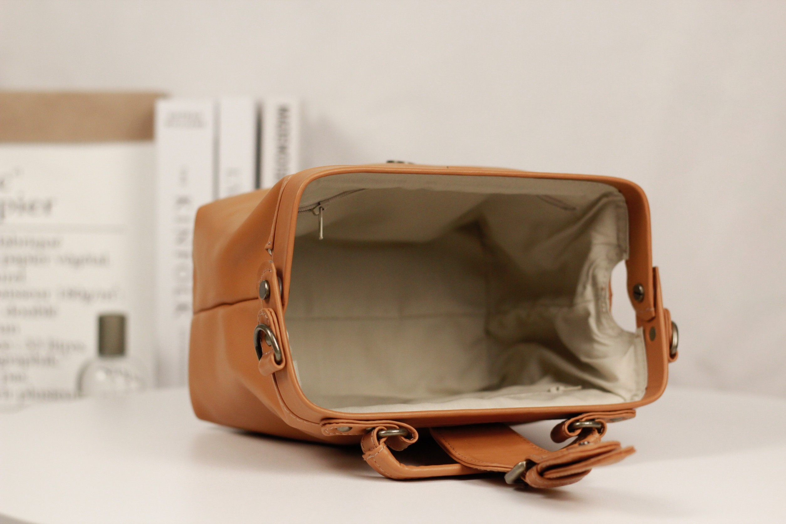 琥珀橙黃 Trista 醫生包橫躺展示空包內部容量與結構,無物品填充情境