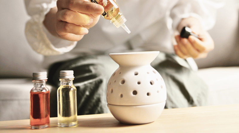 手將香氛油滴入陶瓷擴香器中，示範精油居家擴香的使用方式