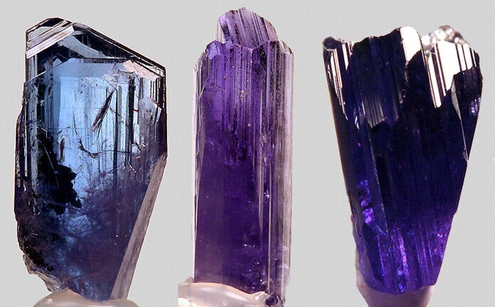 Raw tanzanite crystal showing pleochroism, displaying vivid blue, violet, and purple hues from different viewing angles.