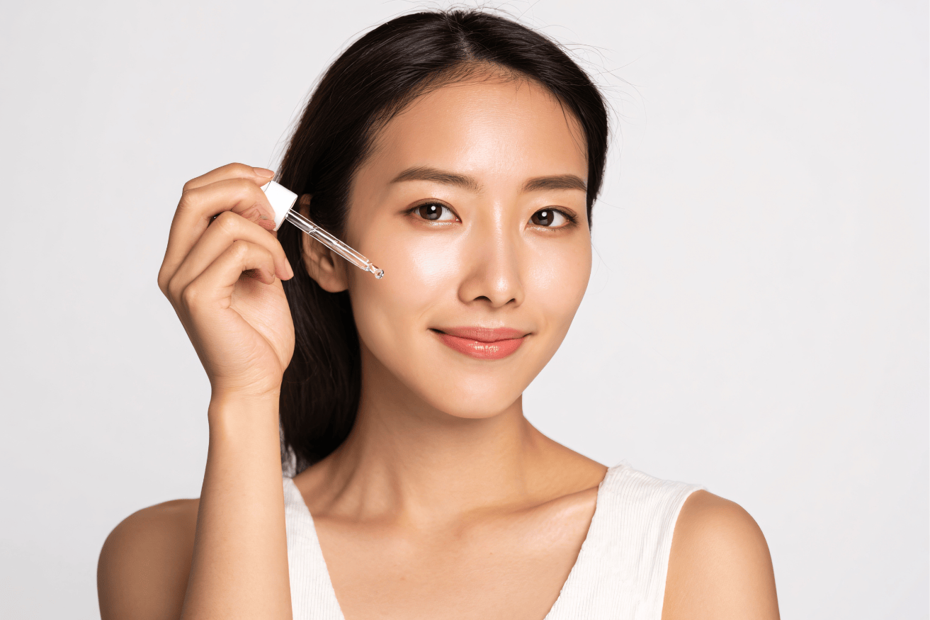 年輕女性使用滴管塗抹精華液，展現簡約清爽的保養日常