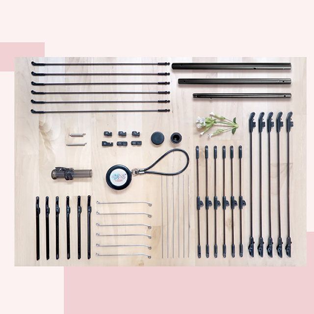 整齊排列的各種雨傘的金屬組件，包括支架、桿子、配件，放置在淺色木質桌面上