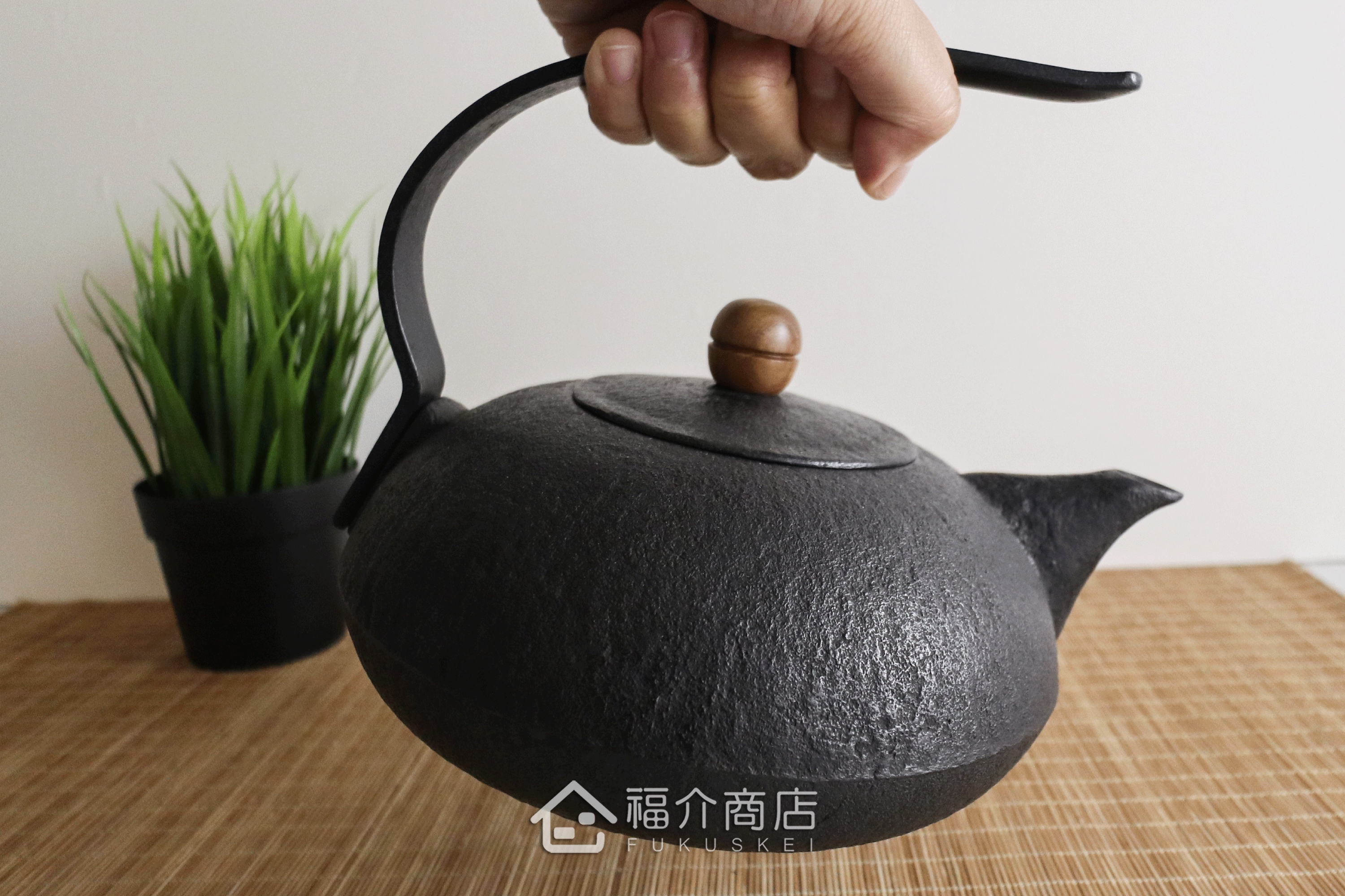 薰山工房所製作的日本鐵壺,ㄑ型的提把，木頭製壺摘