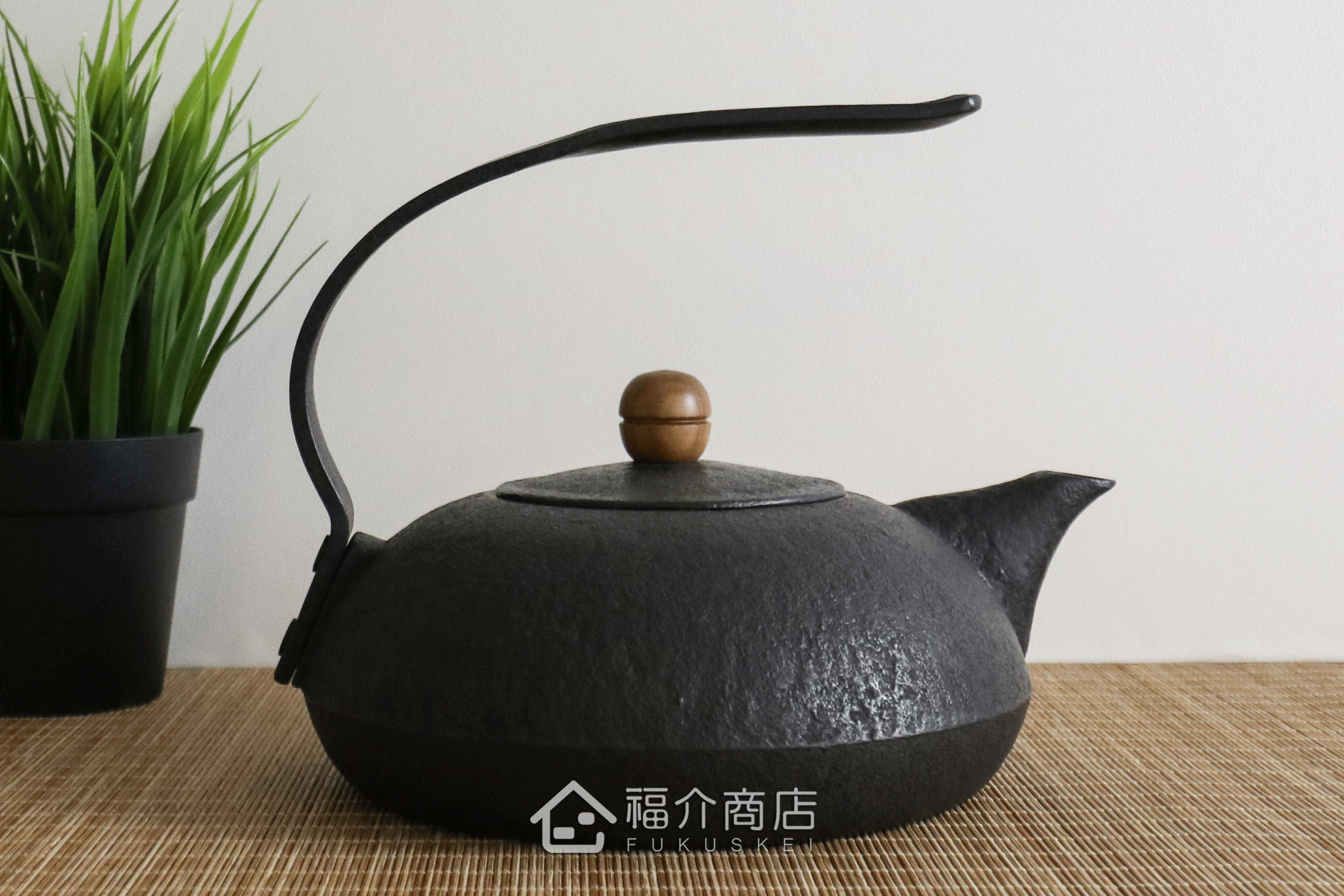 薰山工房所製作的日本鐵壺,ㄑ型的提把，木頭製壺摘