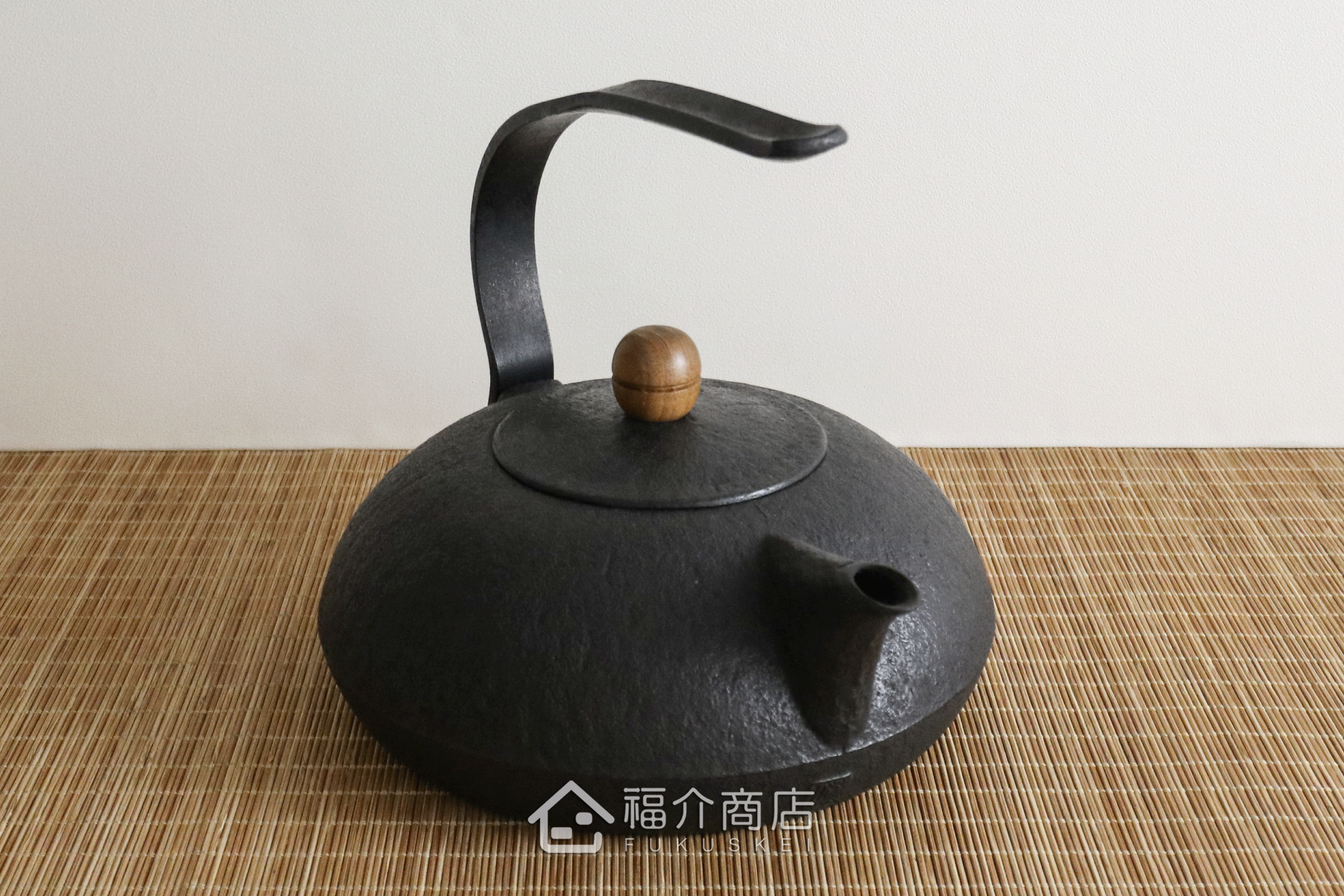 薰山工房所製作的日本鐵壺,ㄑ型的提把，木頭製壺摘