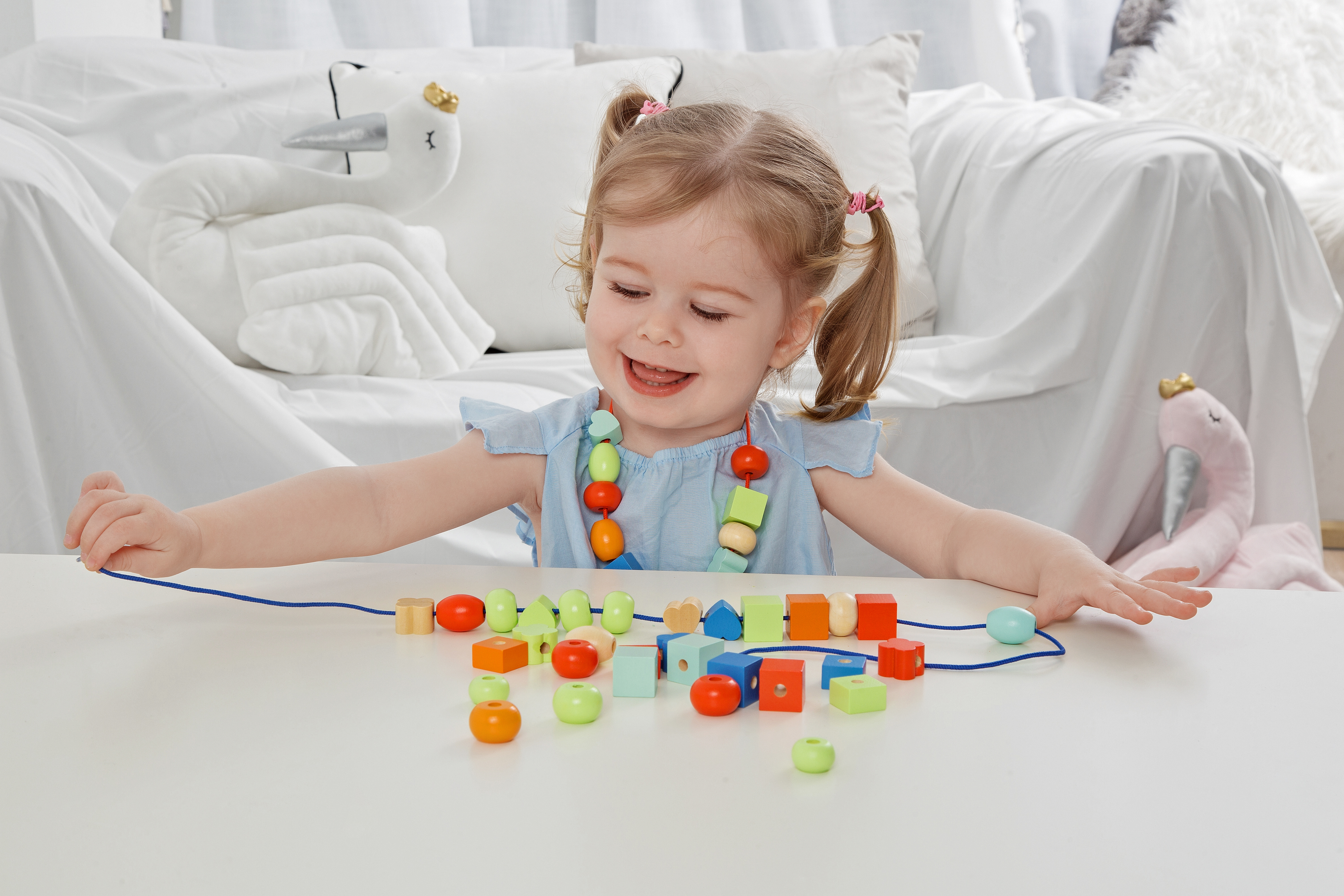 Classic World 繽紛串珠玩具，包含多種色彩與造型的木製珠子和串線。