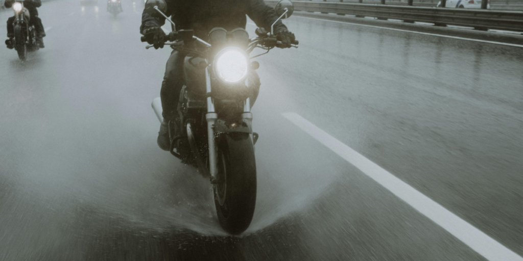 雨天機車行駛在積水路面，展示水漂風險的示意畫面