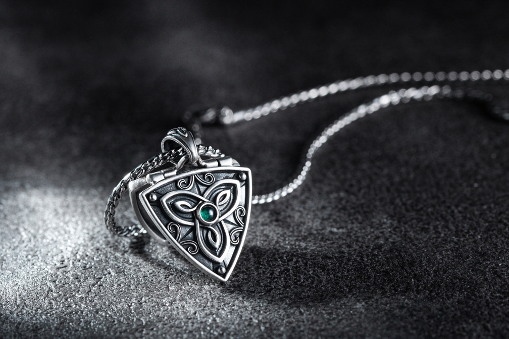 聖靈樹盾開合純銀吊墜商品照,呈現三位一體結與生命之樹浮雕圖騰,搭配綠色寶石點綴及可開合的純銀盾牌設計。