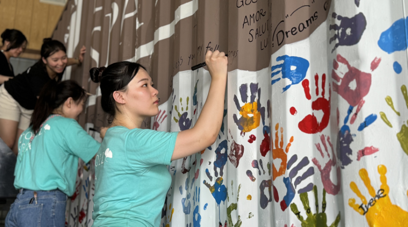 逗DOLLSPA團隊以畫筆築起希望教室  此次彩繪計畫由美容師親自操筆，利用繽紛色彩在貨櫃外牆上畫上花朵、動物、太陽與文字祝福，讓冰冷的貨櫃搖身一變成為溫暖的學習空間。甚至站上堆高機與梯子，細膩完成高處細節，展現高度用心。逗DOLLSPA 表示，希望這些色彩與圖像能成為孩子們心中一座「來自遠方的擁抱」，即便彼此未曾謀面，也能感受到關愛的能量。