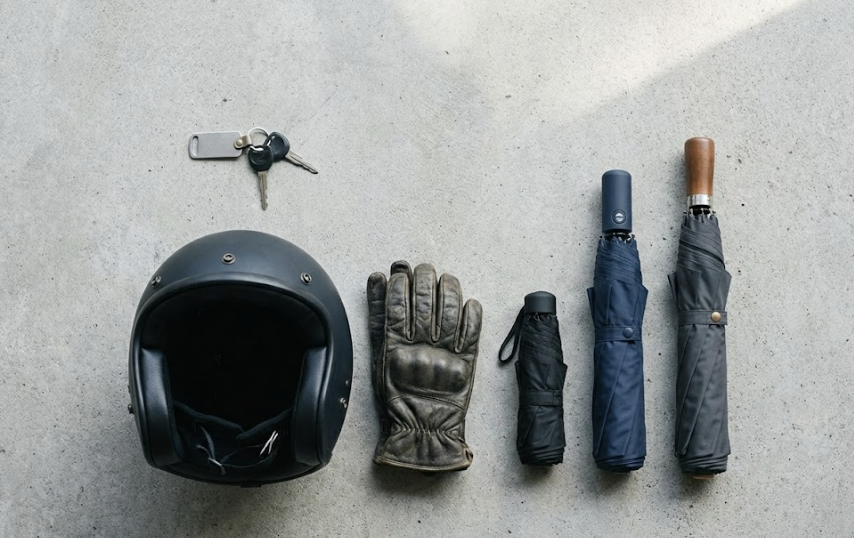 桌面平鋪擺放機車鑰匙、安全帽與三種折疊傘尺寸對比