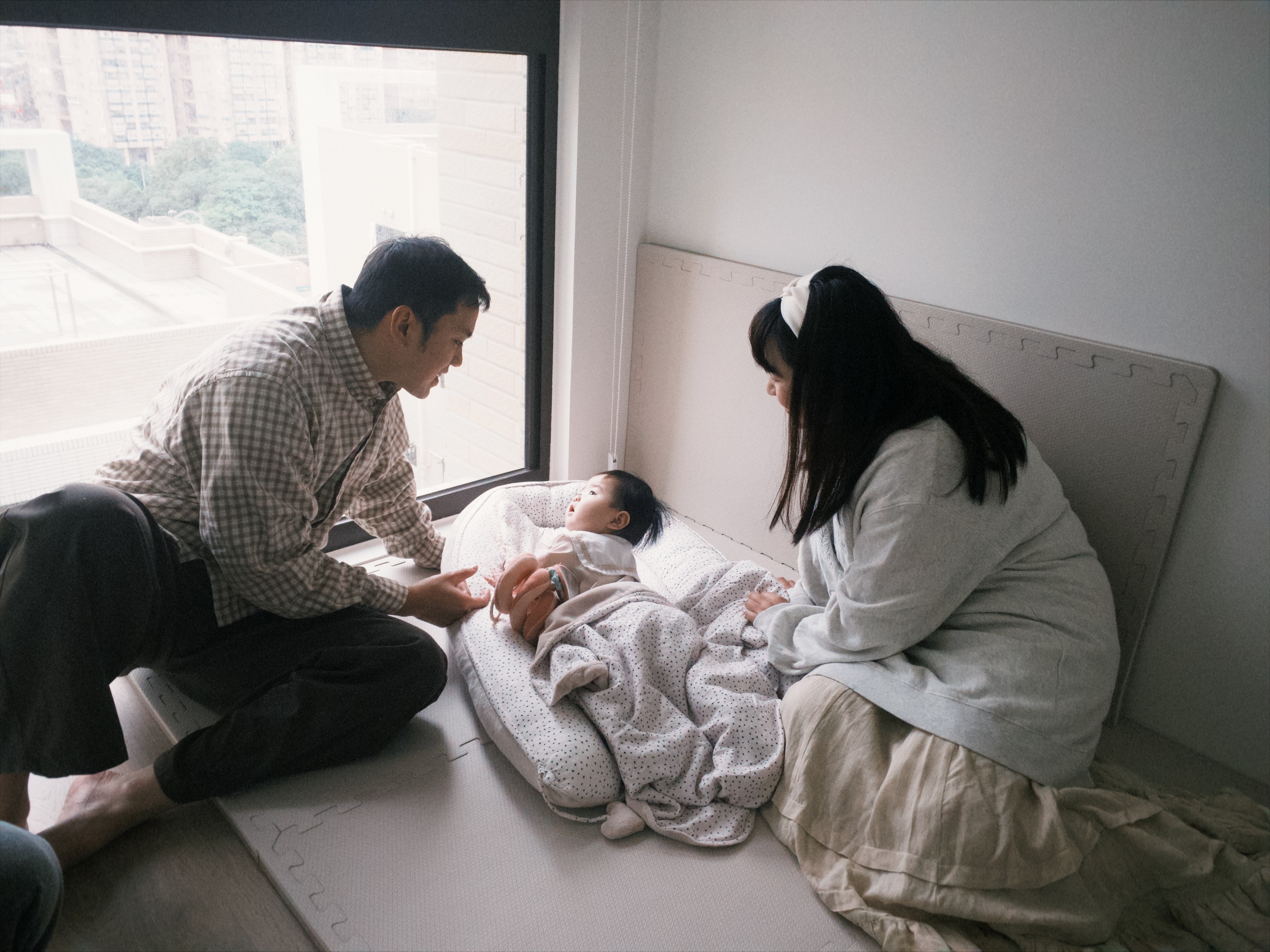 爸媽陪伴寶寶在米蘭暖陽睡窩中的溫馨親子時光，展現嬰兒房留白美學與質感睡眠空間佈置。