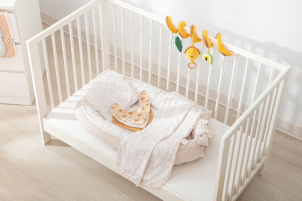 嬰兒床中的米蘭暖陽睡窩暖夢4件組完整陳列，搭配獅子造型床邊吊飾展現質感嬰兒房佈置靈感。