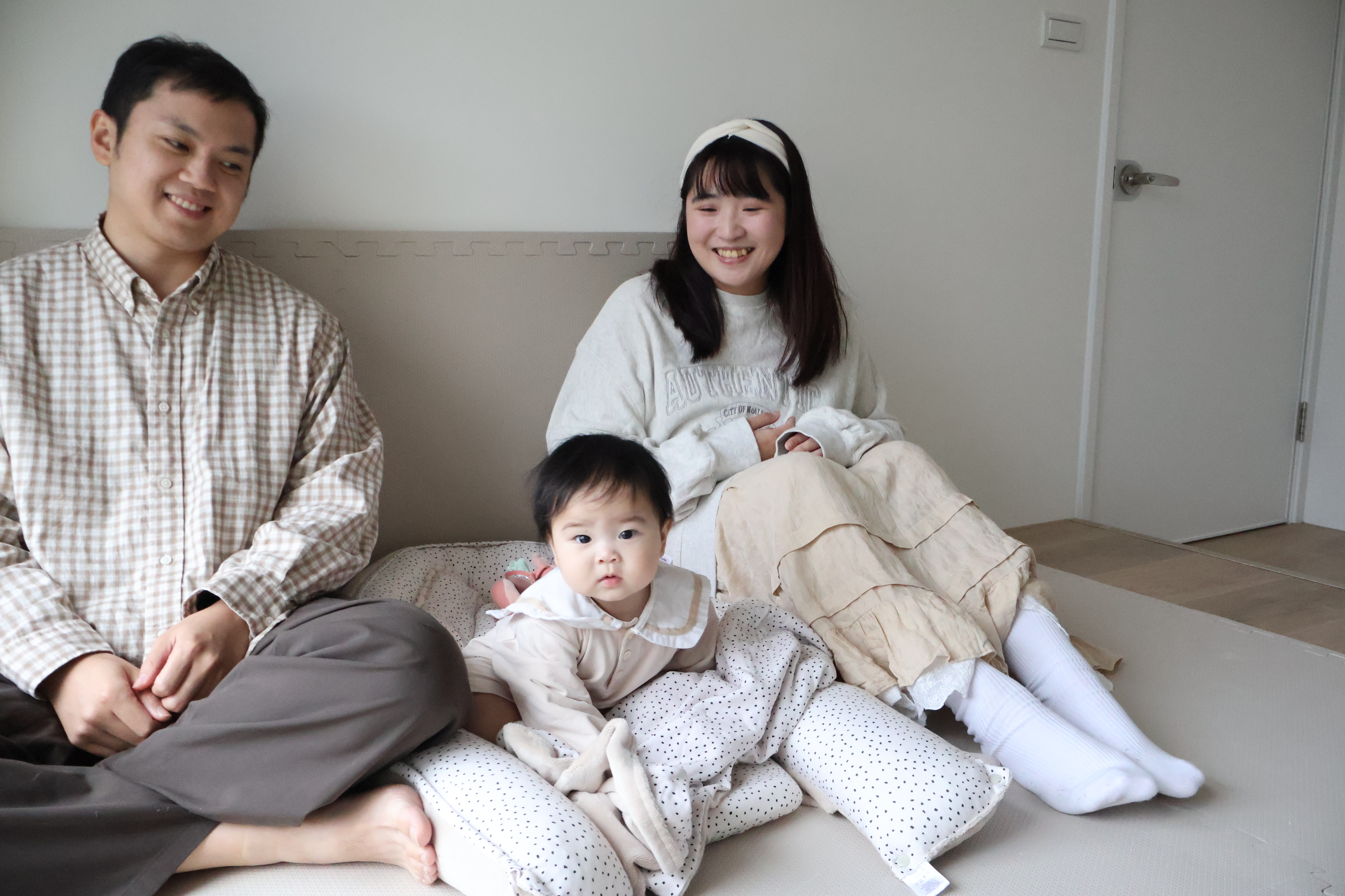 一家三口在米蘭暖陽睡窩暖夢4件組佈置的嬰兒房中的溫馨全家福。