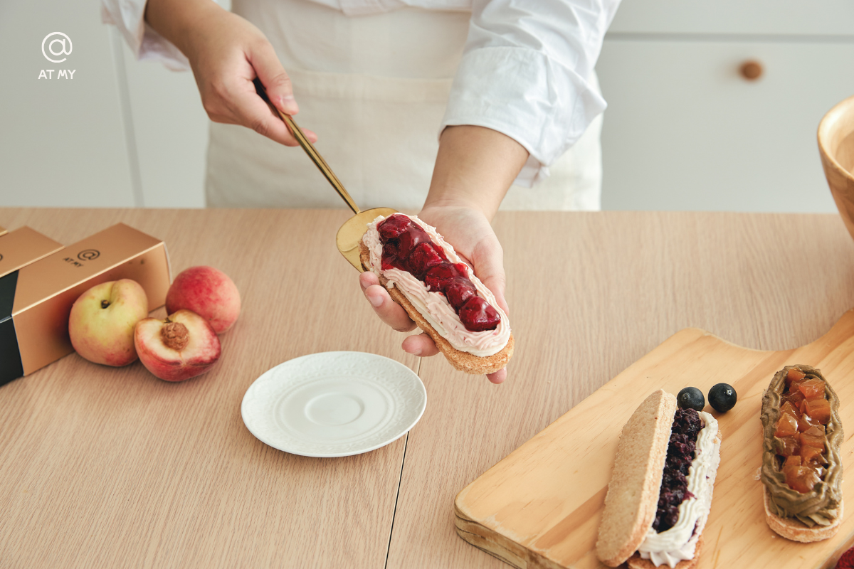 AT MY 法式達克瓦茲甜點近拍，手工填餡畫面展現高質感過年伴手禮的製作細節