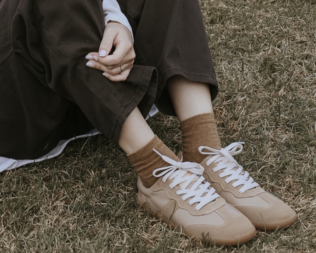 Sanly Joy防潑水德訓鞋 奶茶色(可可色)特寫，在草地上 女孩穿著 呈現文青感。