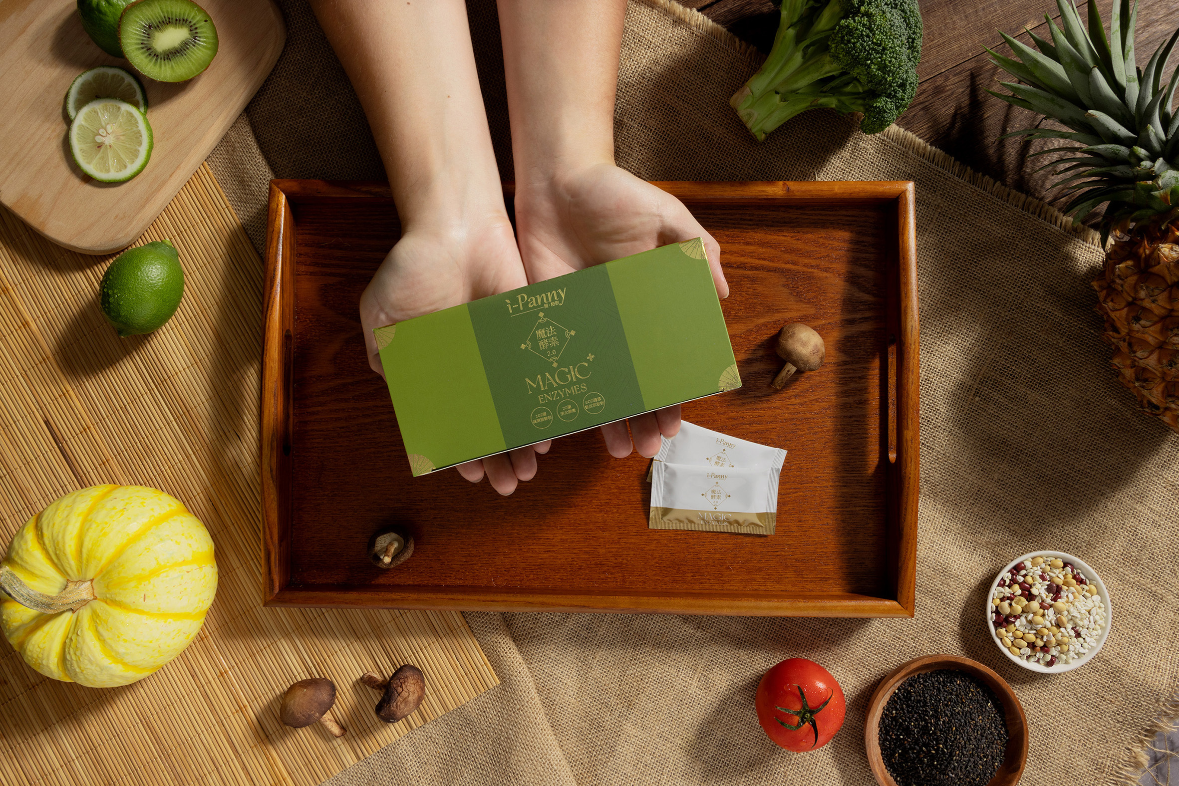 一隻手拿出魔法酵素2.0，旁邊有水果點綴