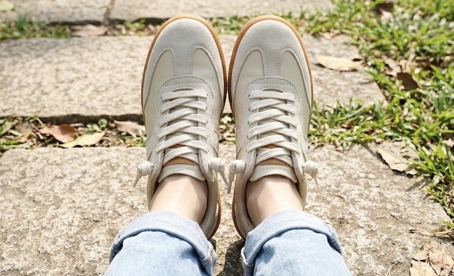 Sanly Joy 艾蜜莉德訓鞋的顯瘦穿搭實測，展示 T 字鞋頭設計如何利用視覺切割原理修飾大腳板，讓雙腳看起來更秀氣小巧，是 2026 年取代傳統小白鞋的最佳顯腳小球鞋推薦。