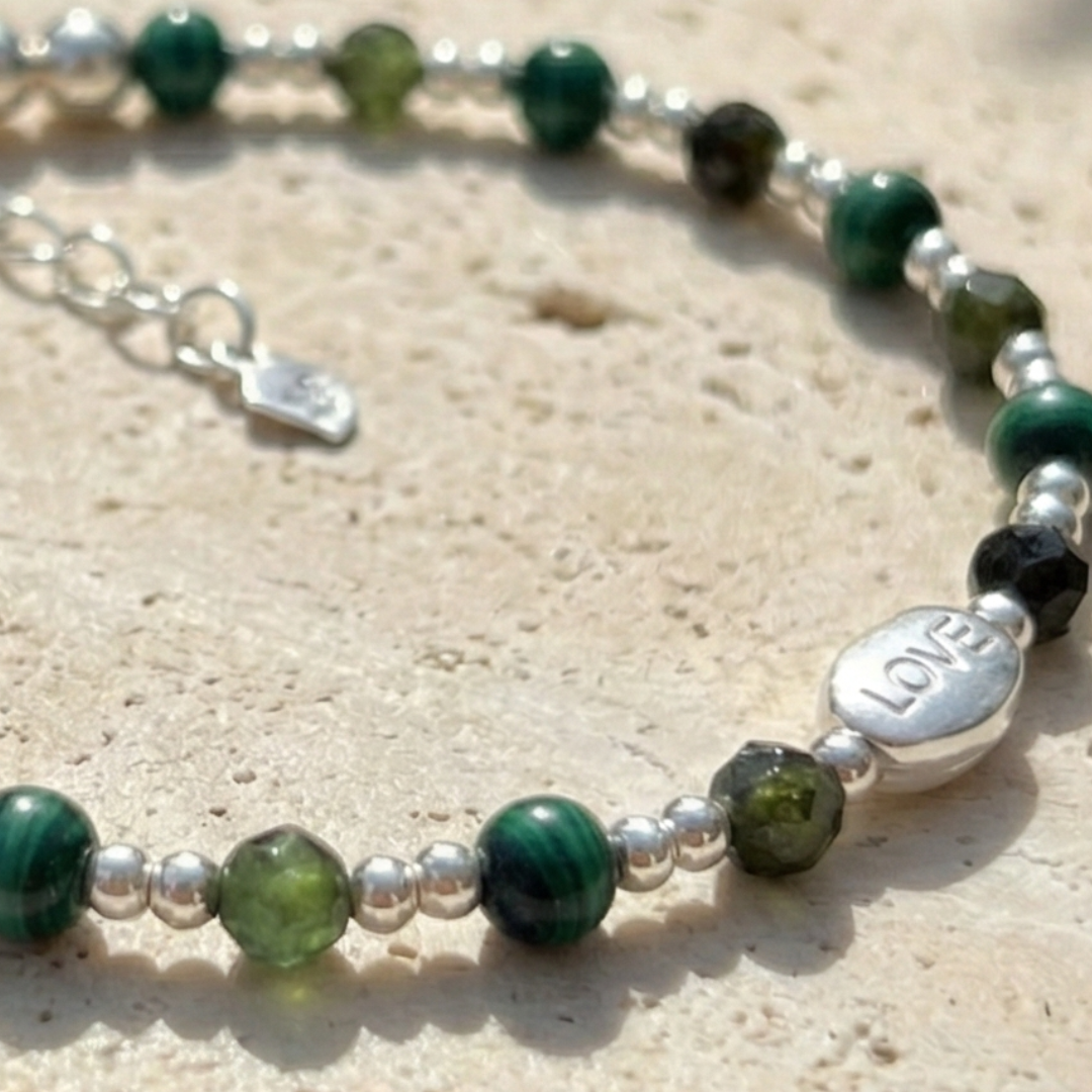 「絕塵・巳蛇」結合孔雀石的轉化力量與綠碧璽的財富續航。