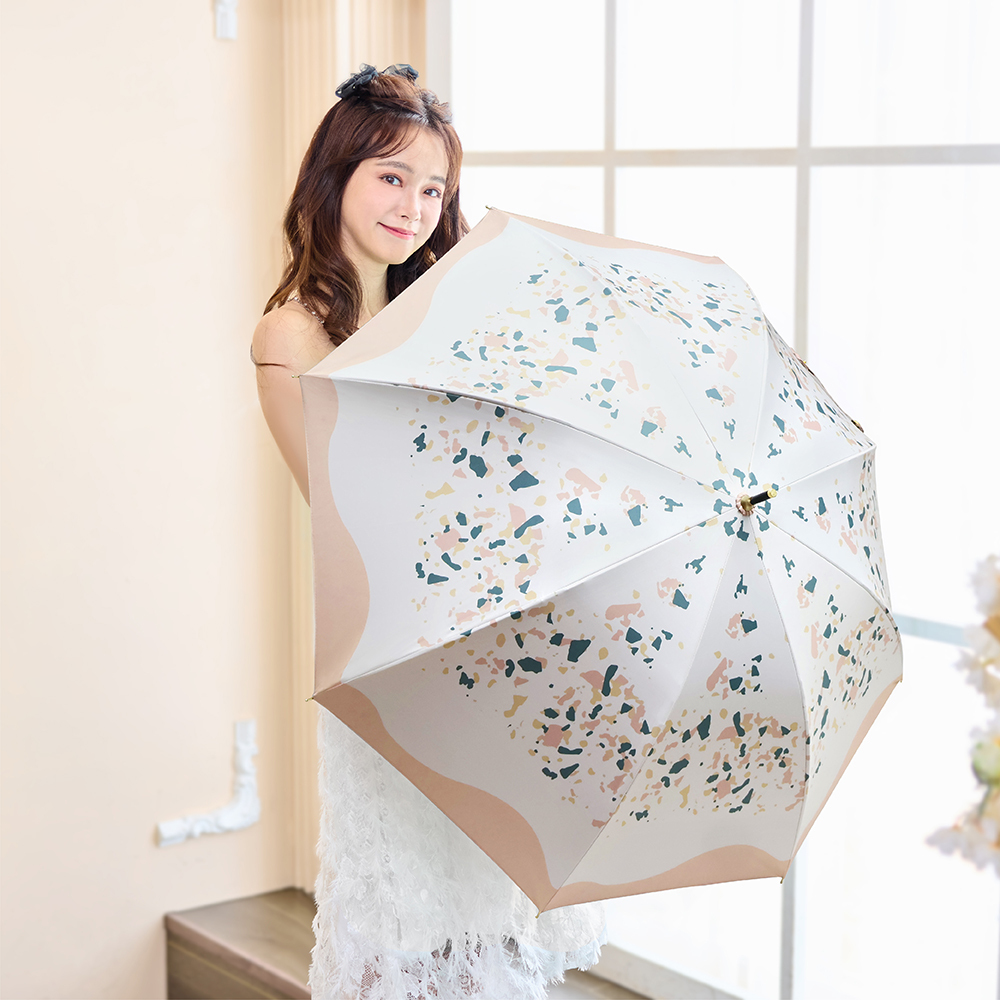 一位年輕女性展示著21吋防曬中長傘日系花影_橘沐，四周放置白花作點綴