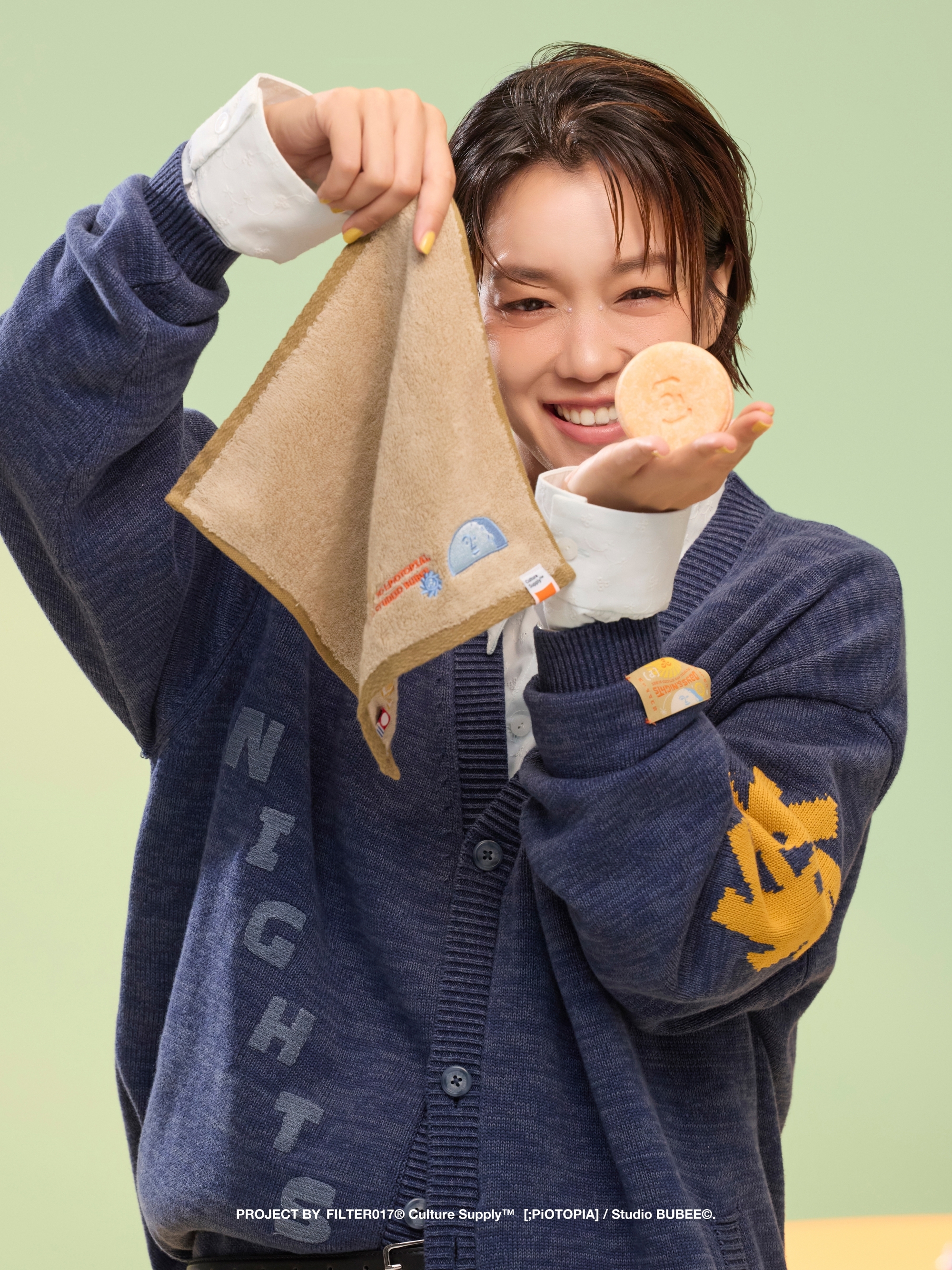 女孩一手拿卡其色刺繡毛巾，一手拿手工皂