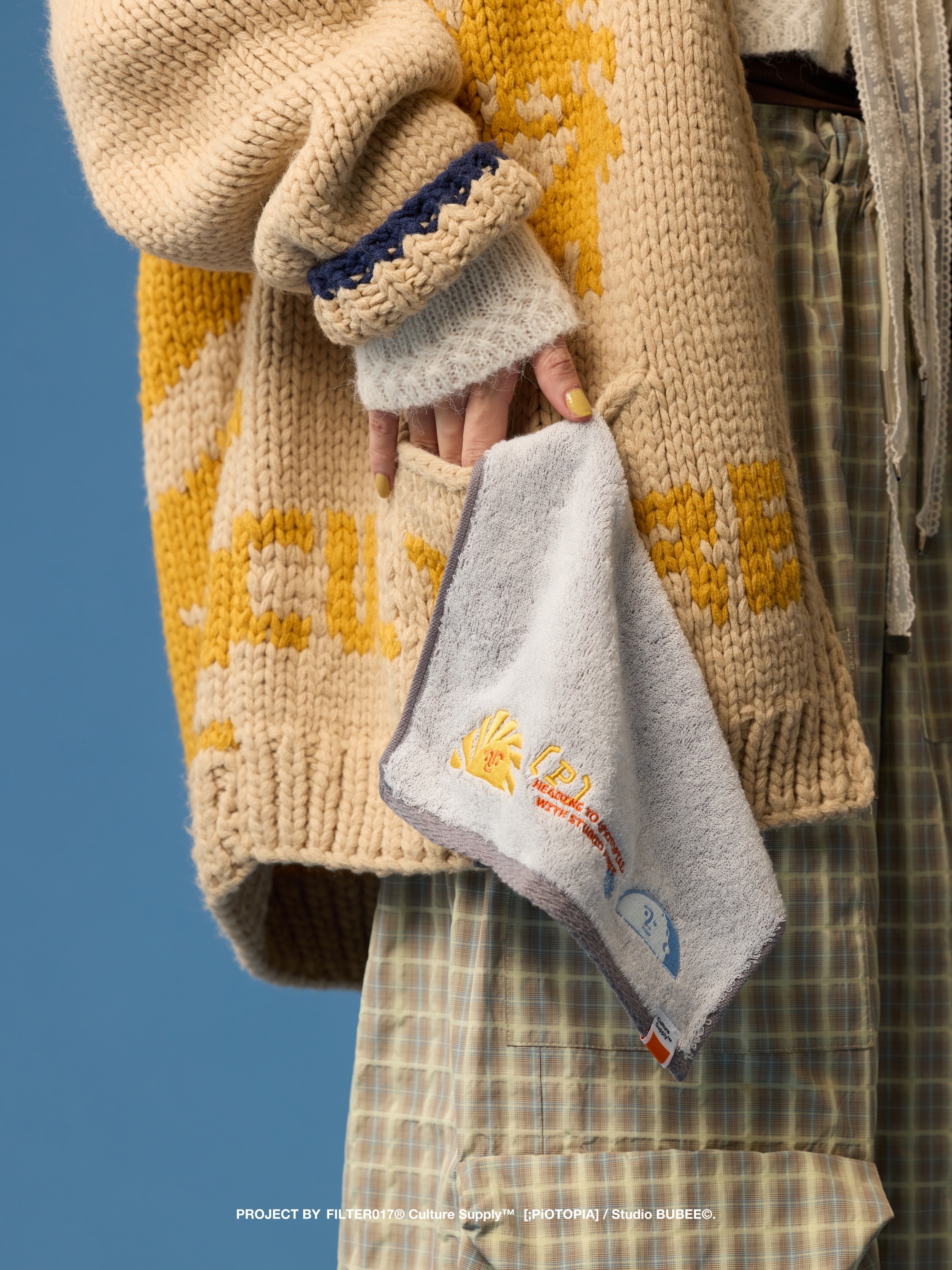 將灰色刺繡毛巾掛於外套口袋