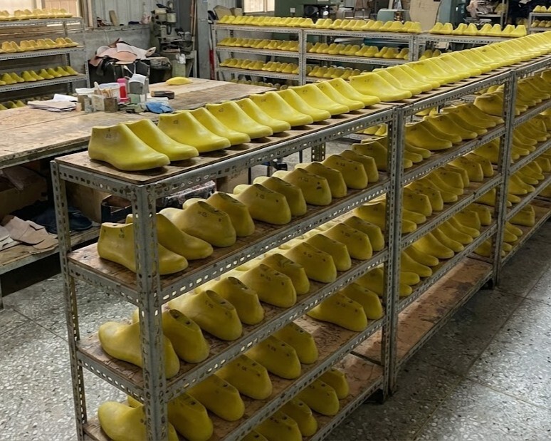 直擊 Sanly Joy 製鞋工廠內部的專屬楦頭庫存，展示針對台灣寬腳板開發的私版黃色模具，強調不使用廉價公版楦頭，投入高額開模成本只為打造最舒適的台灣楦型女鞋。