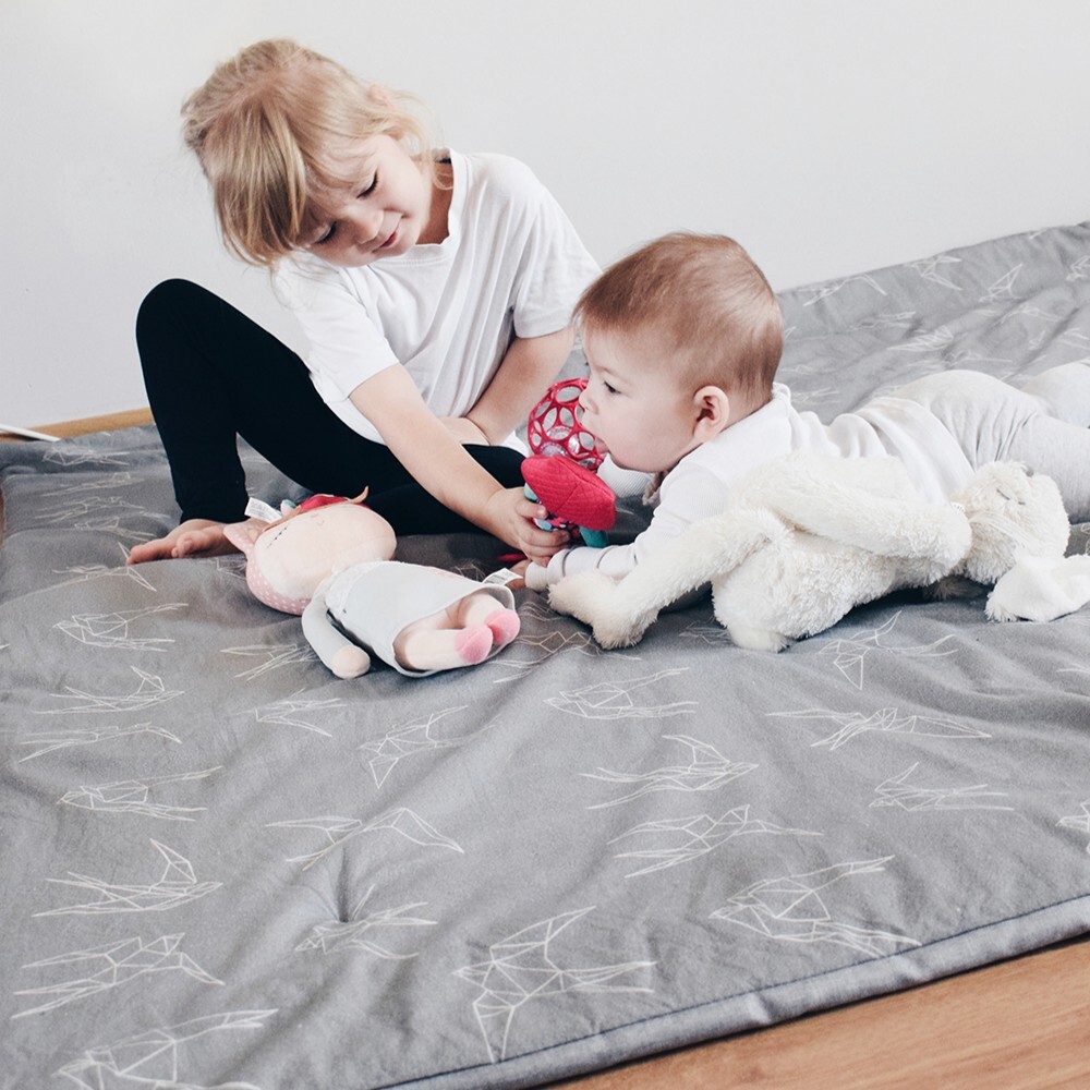 兩位幼兒在灰色幾何飛燕圖案的波蘭 Maylily 竹纖舒芙蕾遊戲軟墊上玩耍，展現防撞地墊的緩衝安全感。