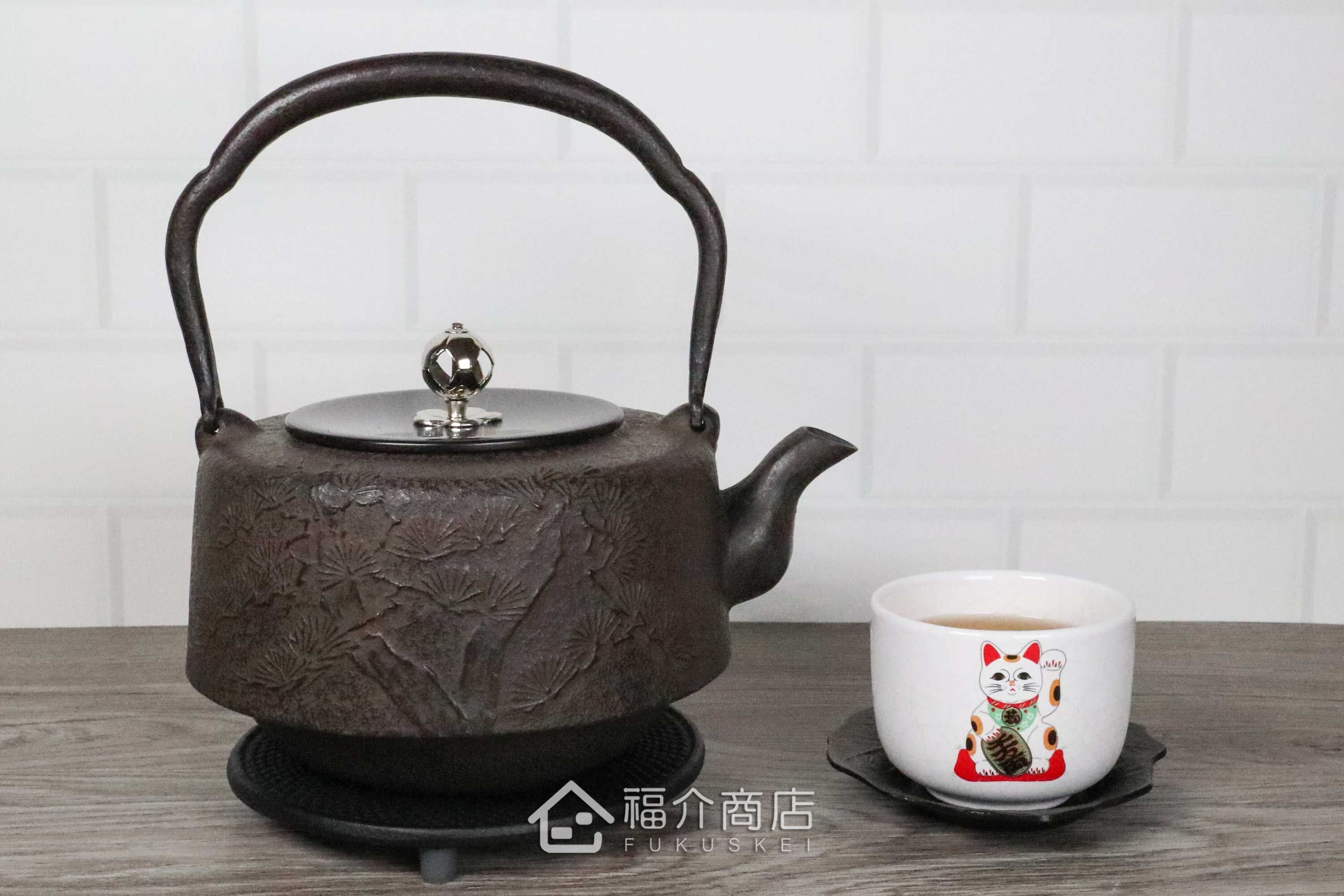 岩戶賢一郎所製作的角萬代型銀摘銅蓋日本鐵壺,壺身設計松樹紋樣,煮水泡茶用的鐵壺