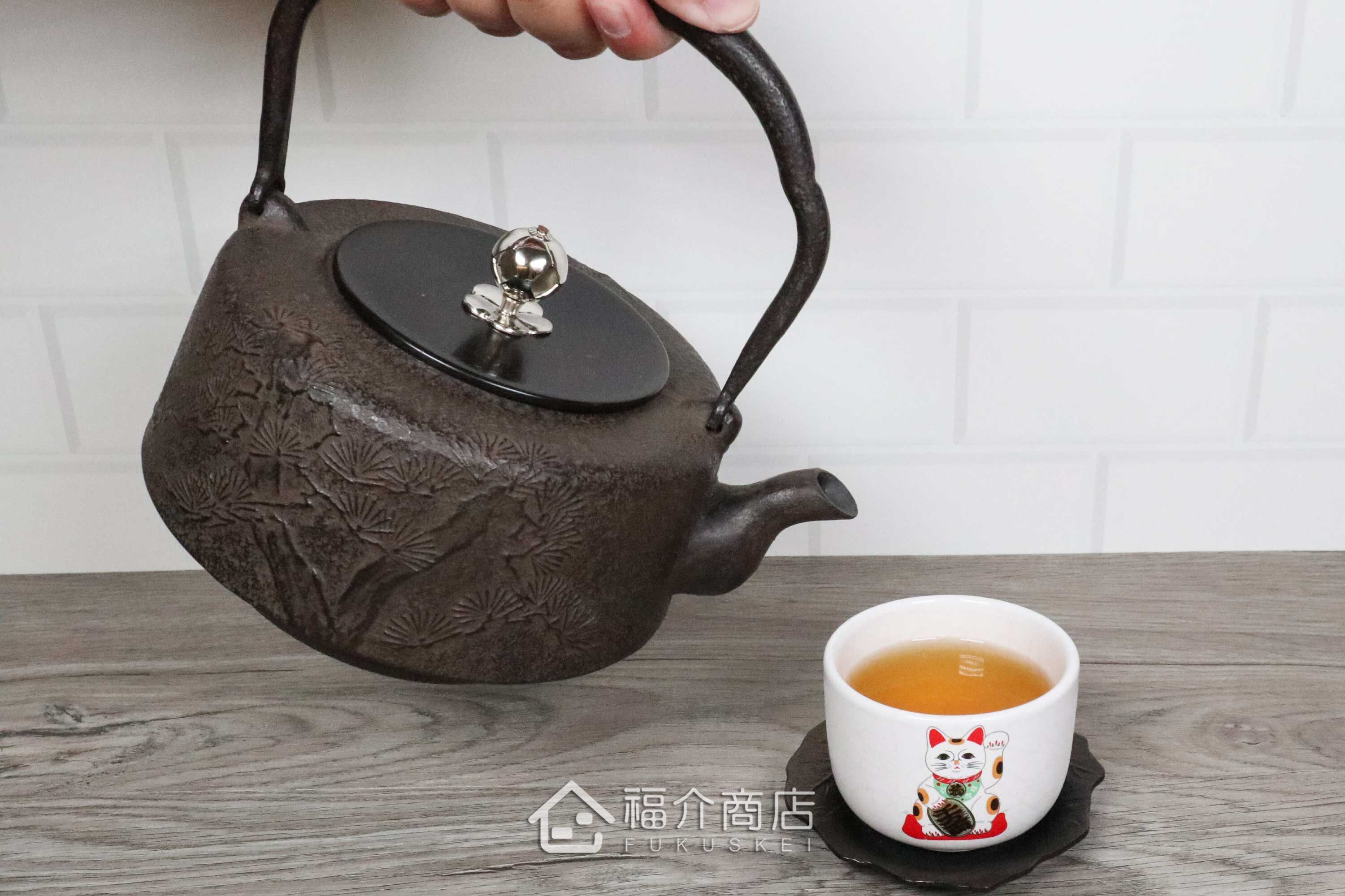 岩戶賢一郎所製作的角萬代型銀摘銅蓋日本鐵壺,壺身設計松樹紋樣,煮水泡茶用的鐵壺