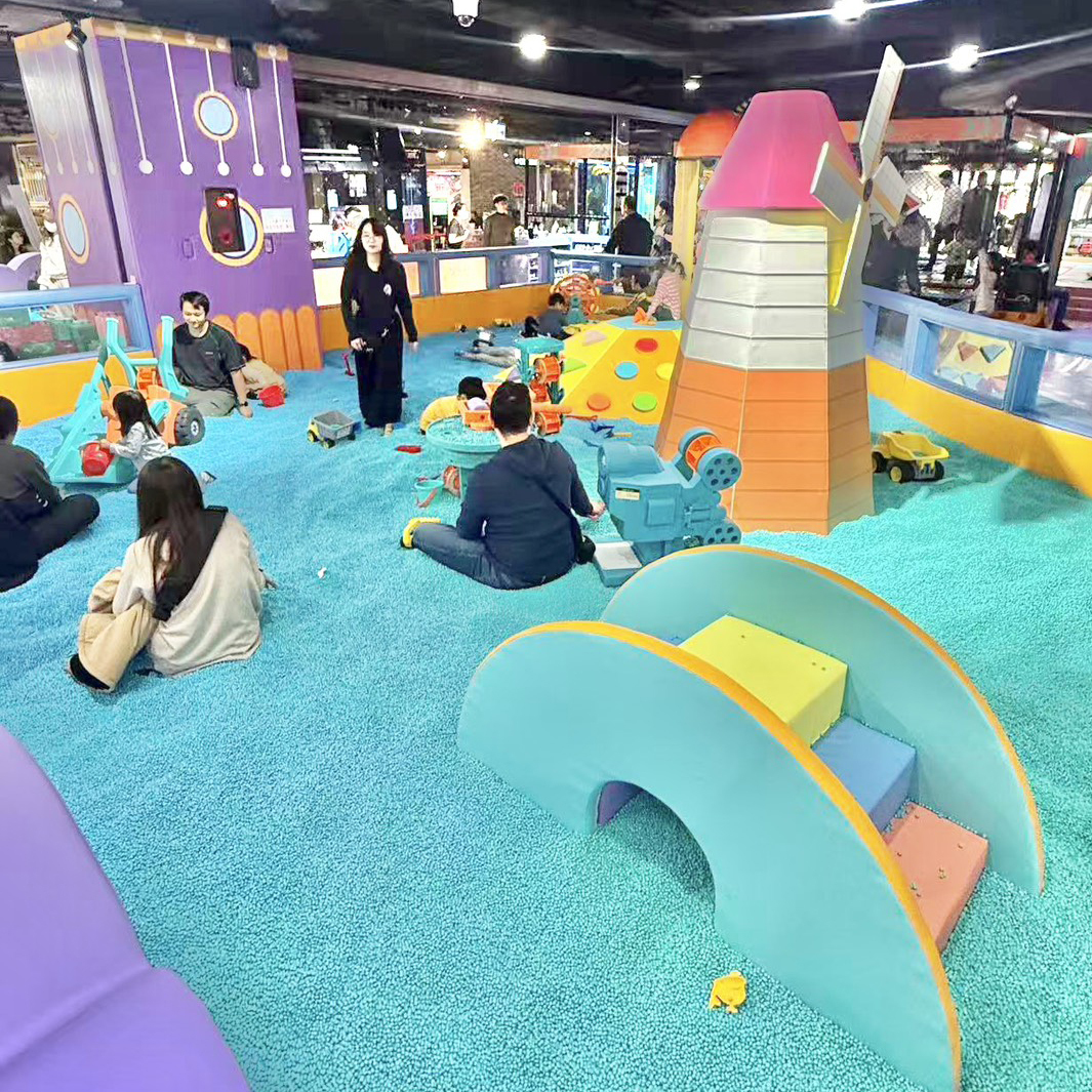 室內親子感統遊戲區，鋪滿柔軟顆粒地面