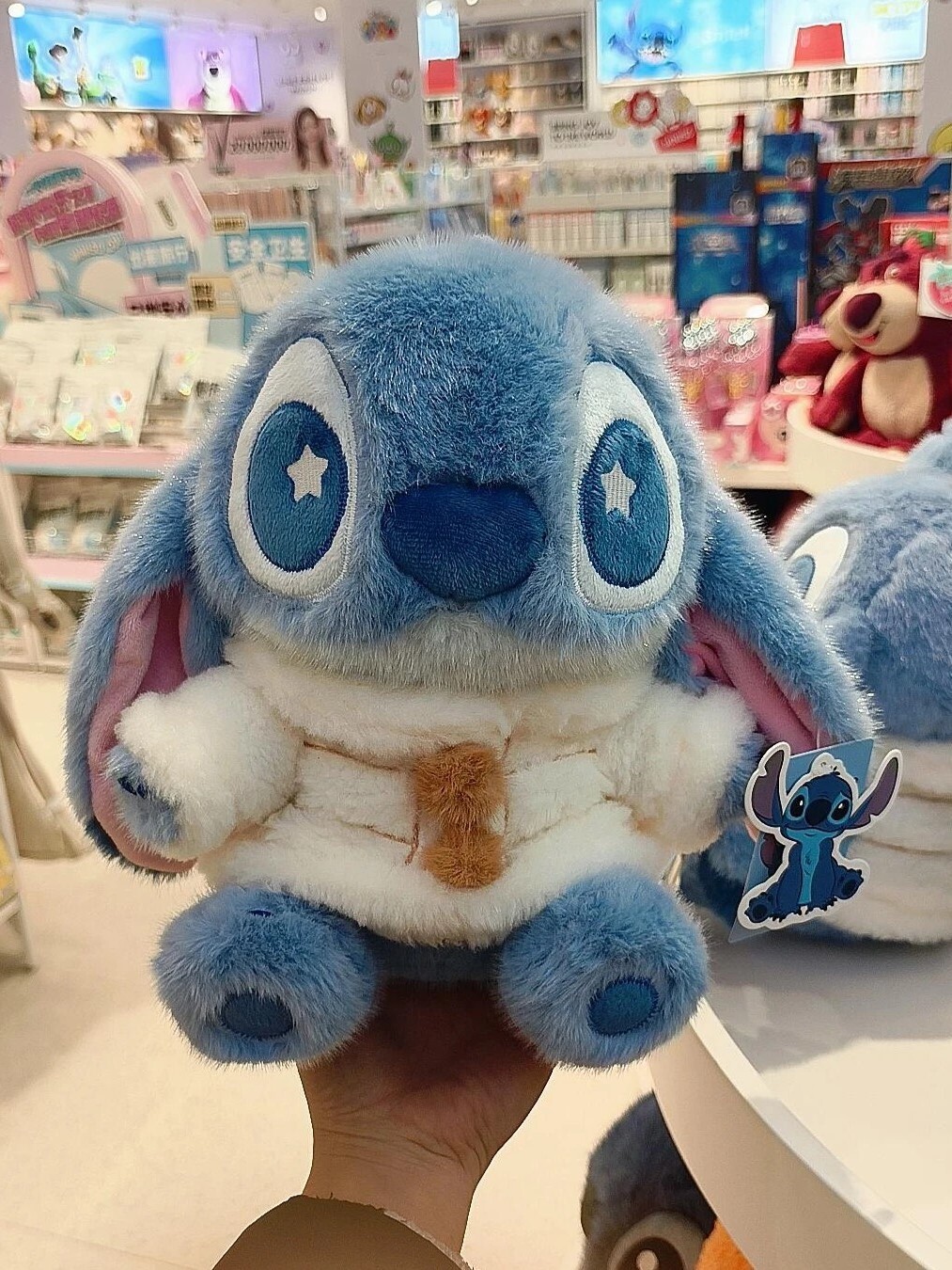 Disney Stitch winter outfit, cozy sitting pose, plush doll.