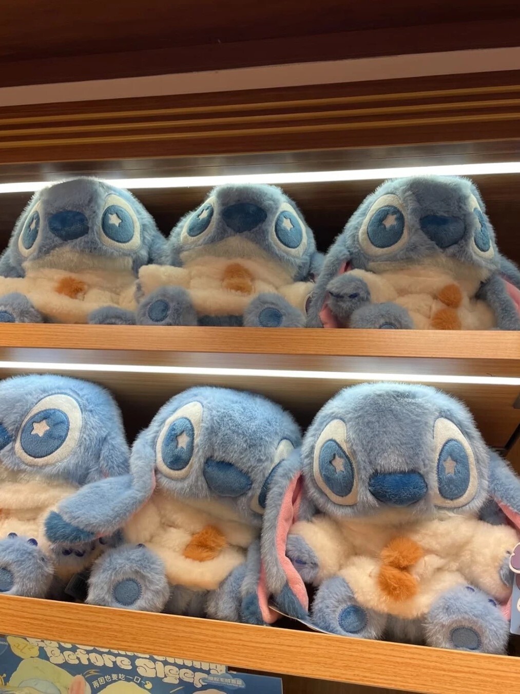 Disney Stitch winter outfit, cozy sitting pose, plush doll.