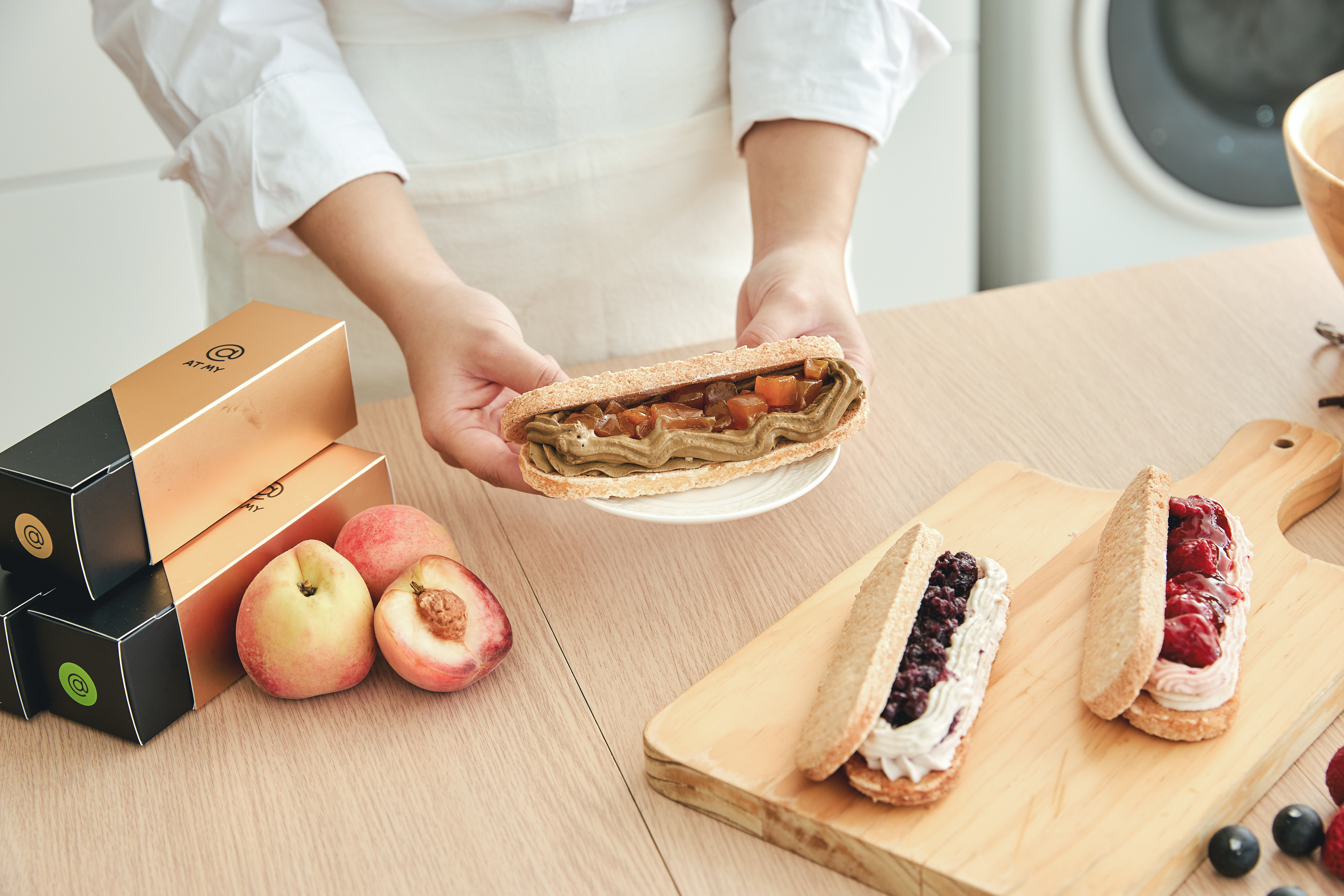 AT MY 手工達克瓦茲甜點製作情境，主廚手持夾入焦糖果丁與滑順奶餡的達克瓦茲，呈現達克瓦茲食譜中外酥內柔、層次分明的法式甜點風味