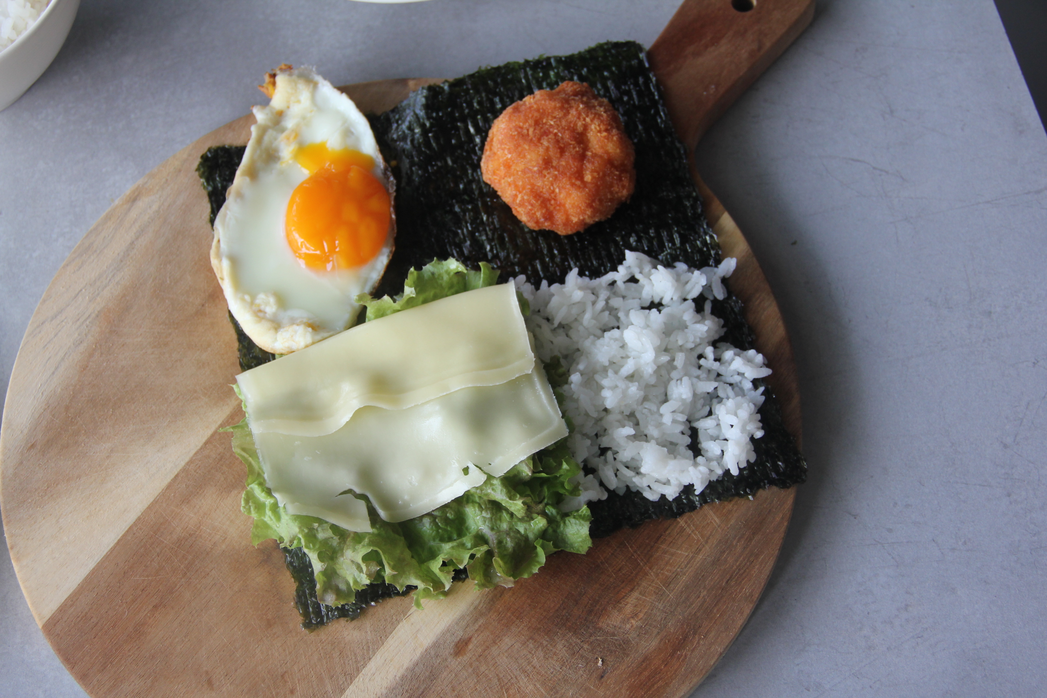 2.把海苔分成四個區塊，依序放入自己喜歡的食材，接著使用上、右、下的順序順時鐘折疊