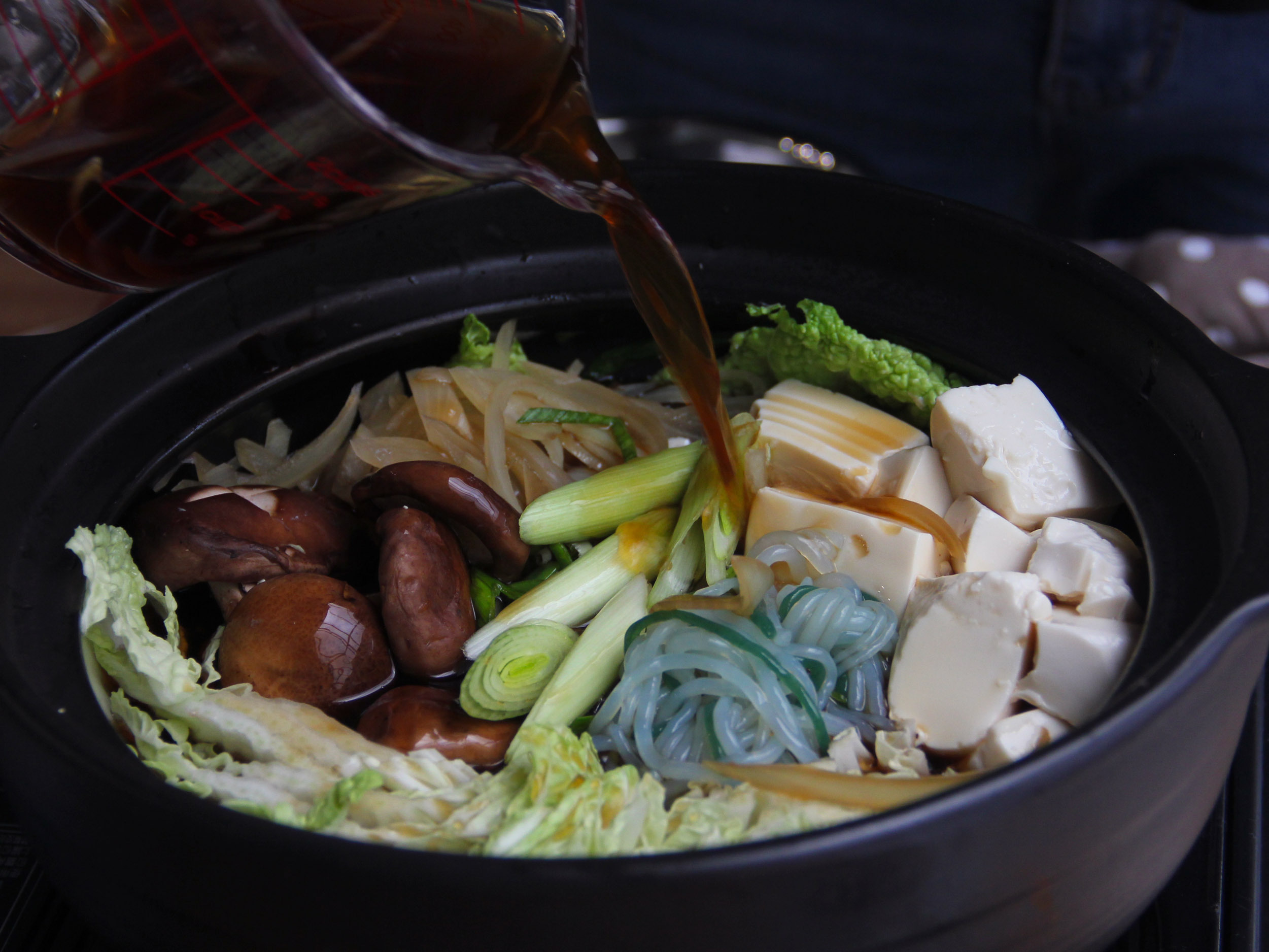 4.同一鍋放入洋蔥絲拌炒，稍微拌炒一下即可，將白菜、豆腐，香菇，蒟洛切成喜愛大小，放入鍋內，倒入壽喜湯汁