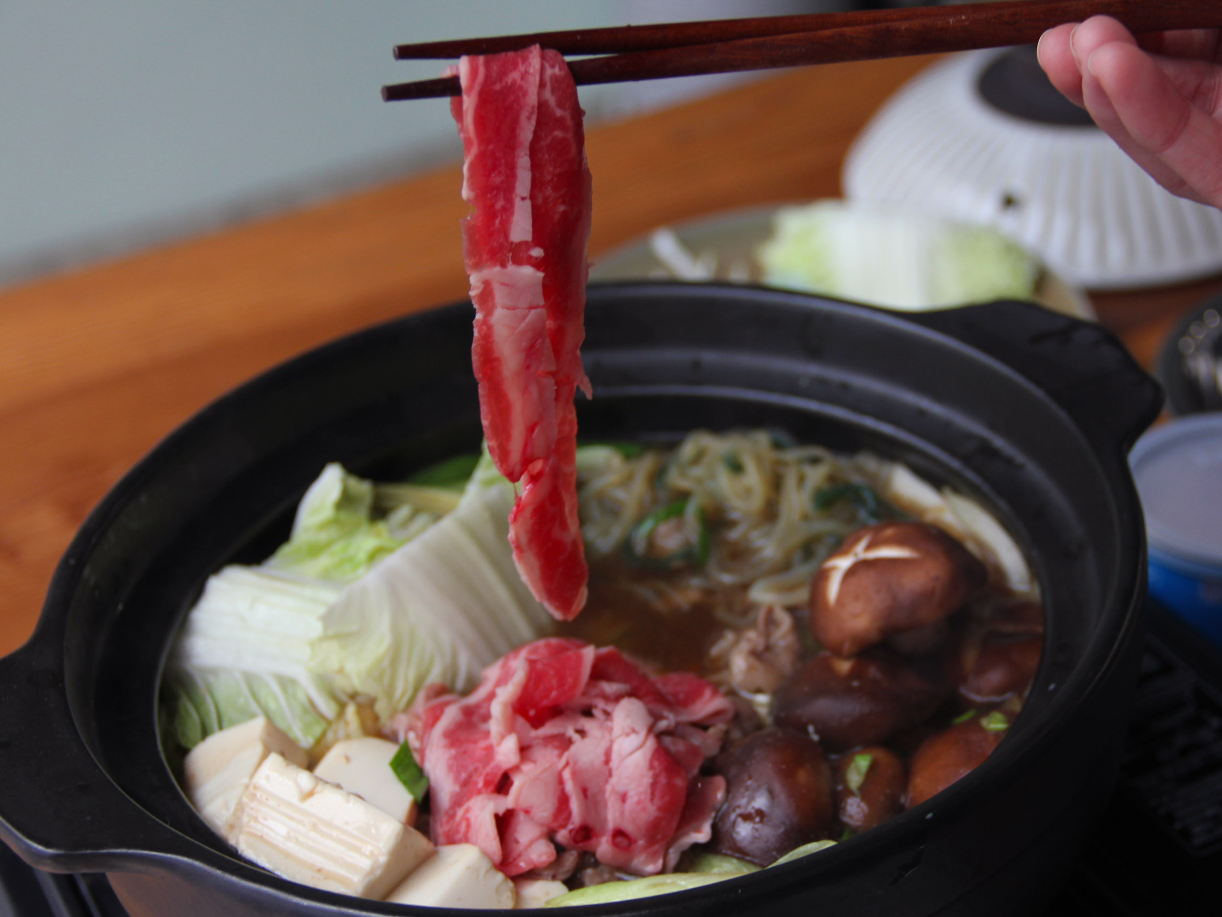 5.將青菜、豆腐、菇類切成喜愛大小，放入鍋中，倒入步驟2，涮入肉片，沾上新鮮蛋