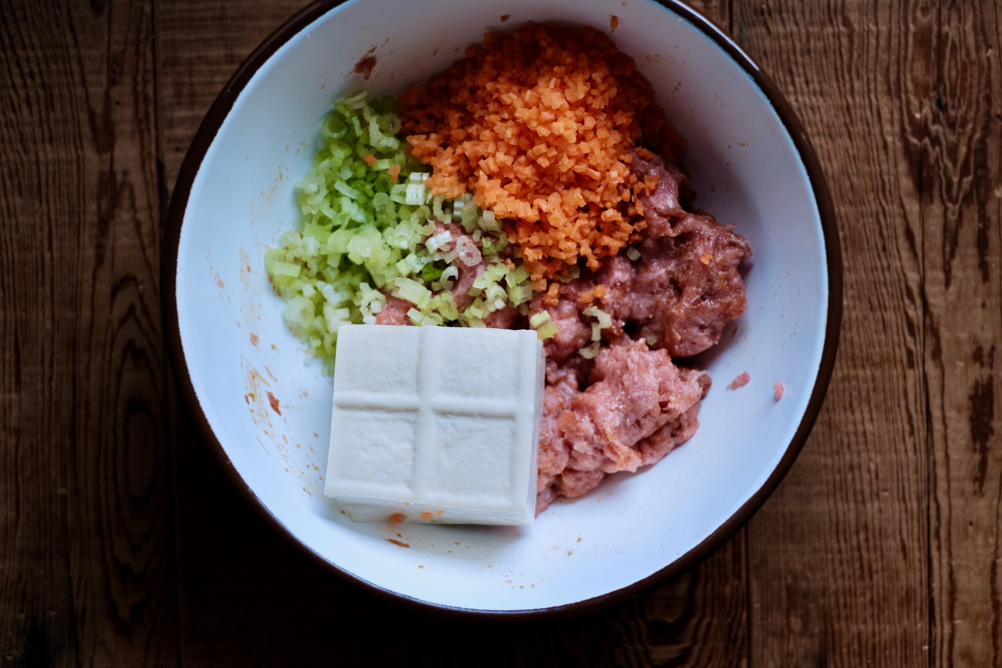 接著放入剩餘的食材與調味料，包括芹菜末、紅蘿蔔末、板豆腐、兩小匙醬油、一小匙香油。