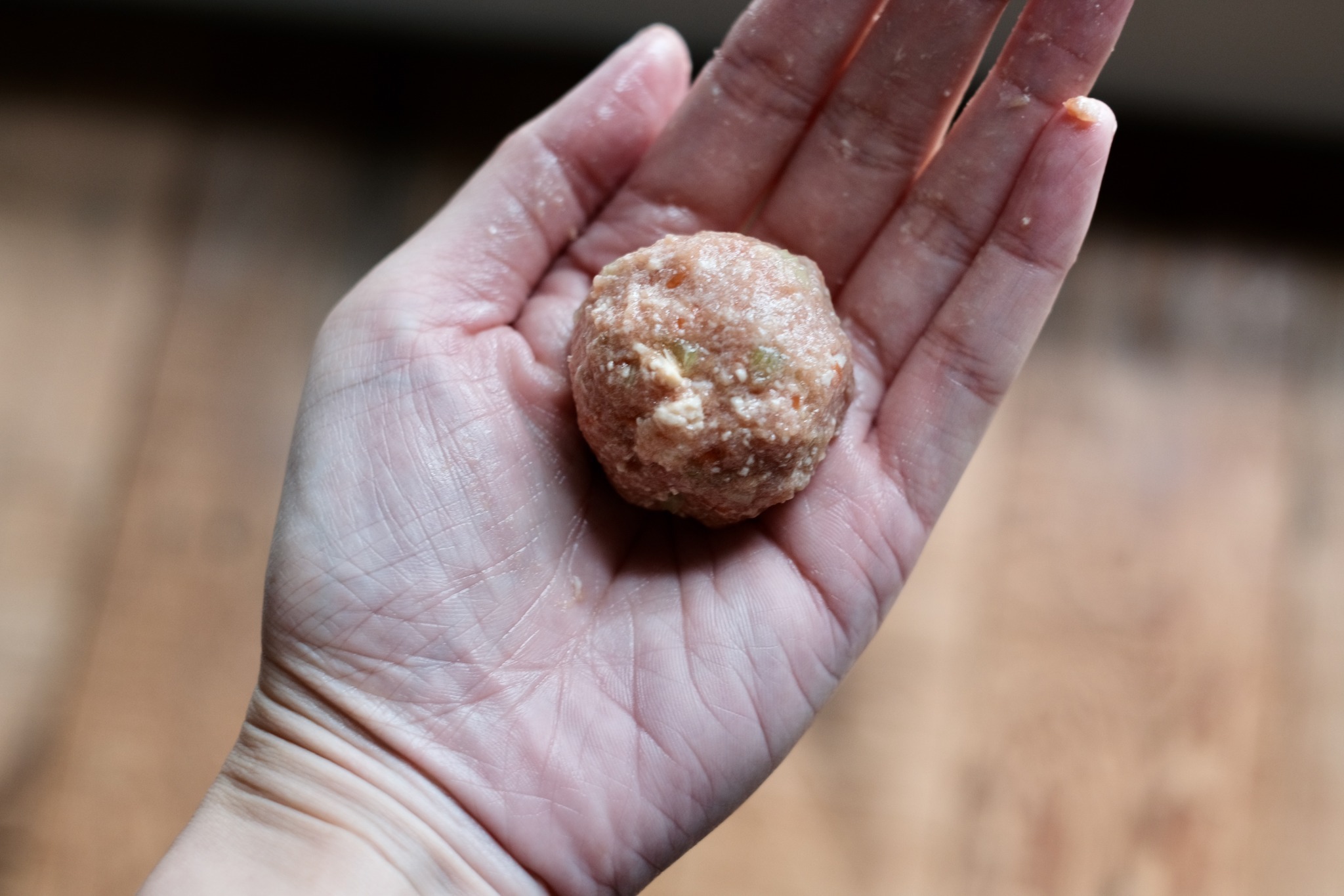 取一小坨放在手心，用手搓揉成肉丸。肉餡很綿密，很快就能搓成像照片中光滑細緻的狀態。