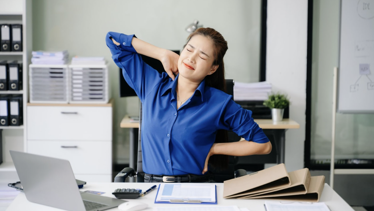 辦公室女性上班族久坐後感到肩頸與下背痠痛,手扶脖子與腰部露出不適表情