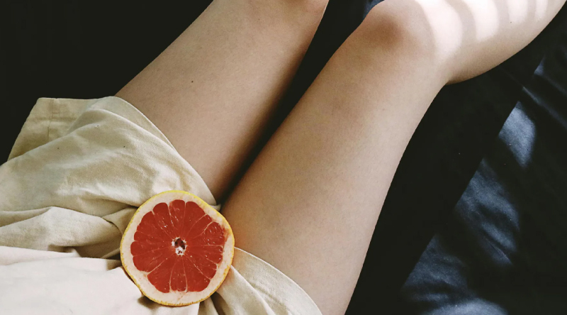 女人腿上放著橘子切片