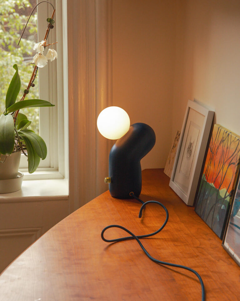 Talbot & Yoon-Doko 桌燈，擁有迷人的擬人化造型，彷彿溫柔地托舉著磨砂玻璃燈泡。
