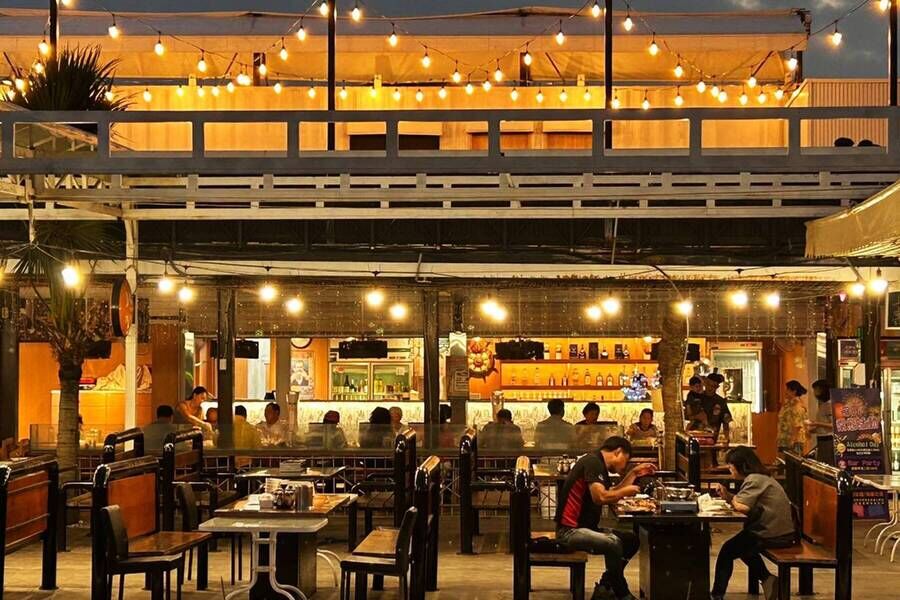 熱鬧的半露天美式景觀餐廳，設有貨櫃屋二樓座席、溫馨的燈泡串裝飾與開放式吧檯